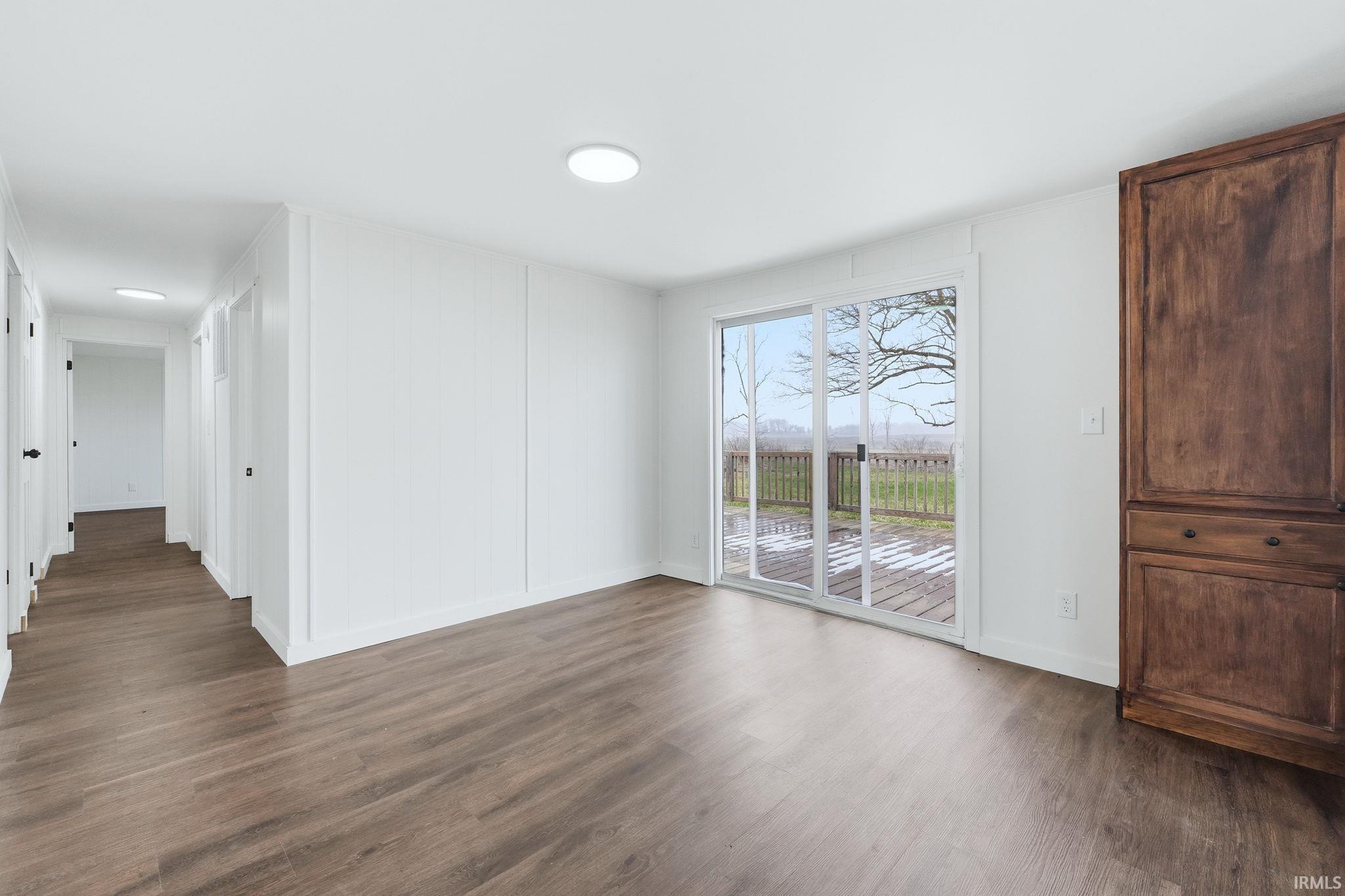 Unfurnished room featuring dark wood-type flooring and baseboards