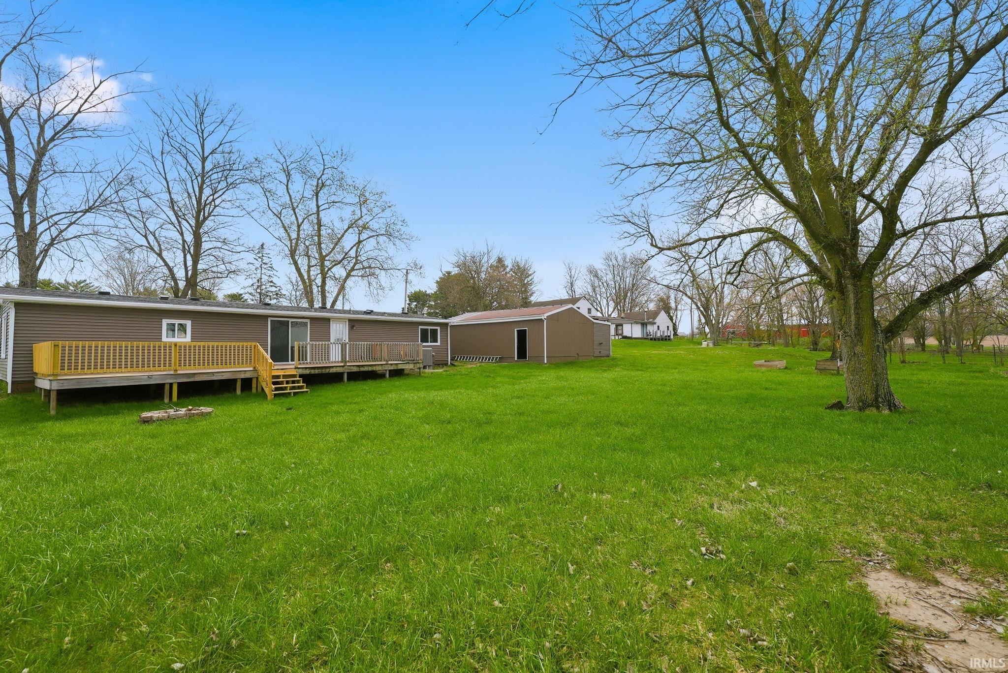 Back of house featuring a lawn and a deck