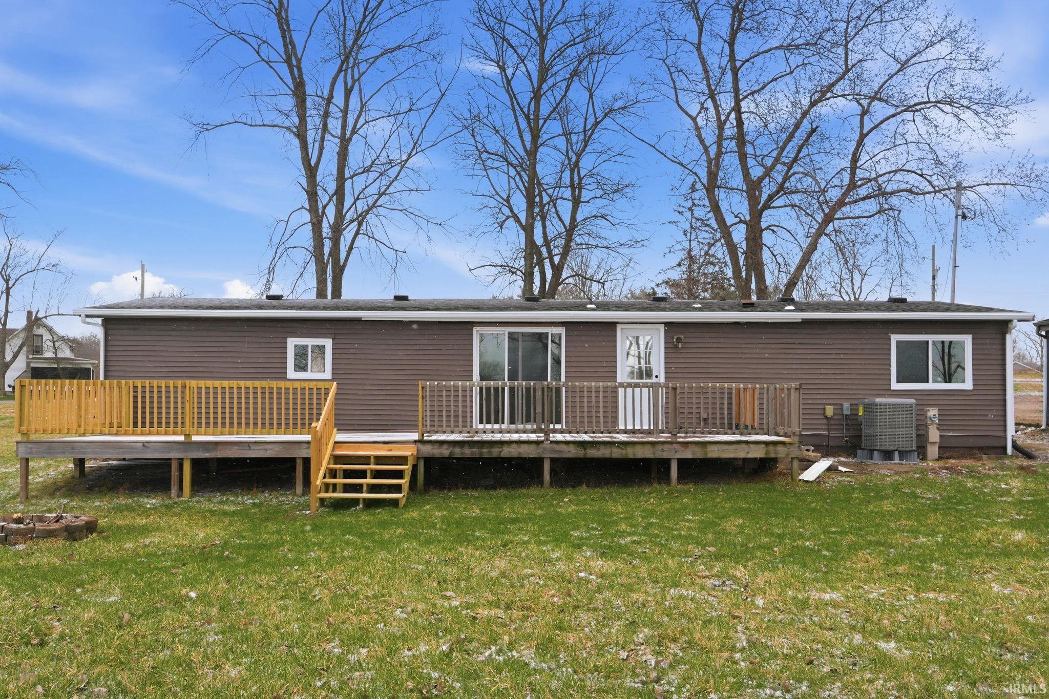 Rear view of property featuring a yard and a deck