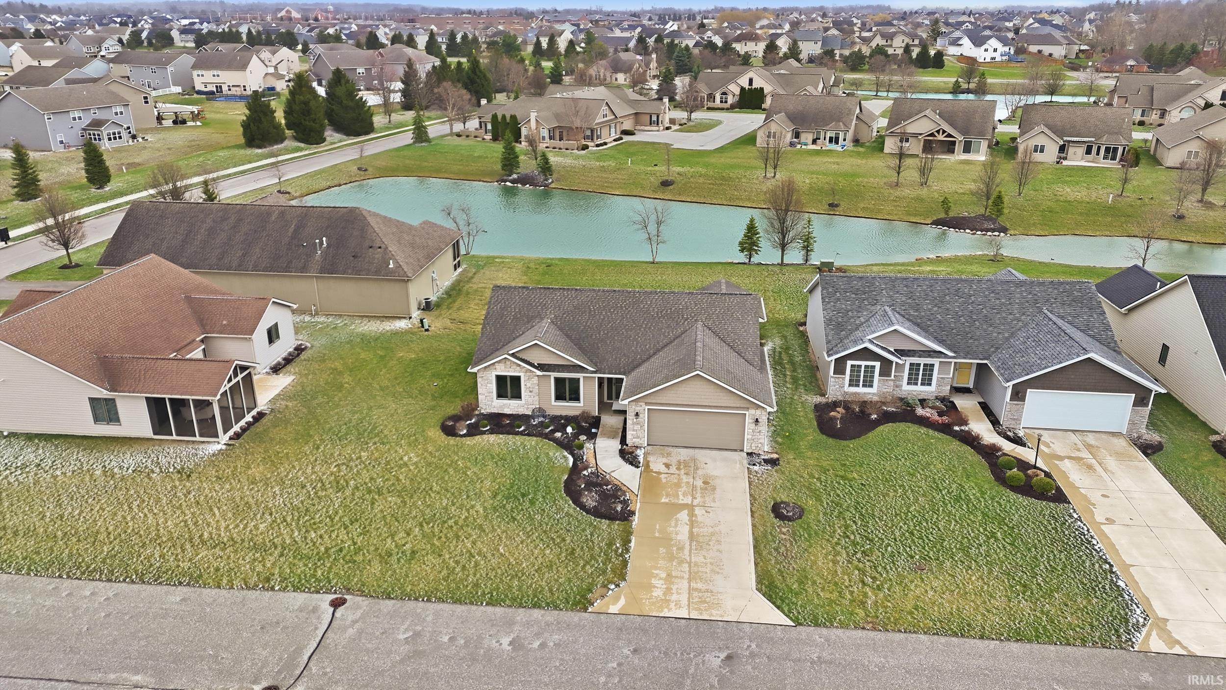 Aerial perspective of suburban area featuring a nearby body of water