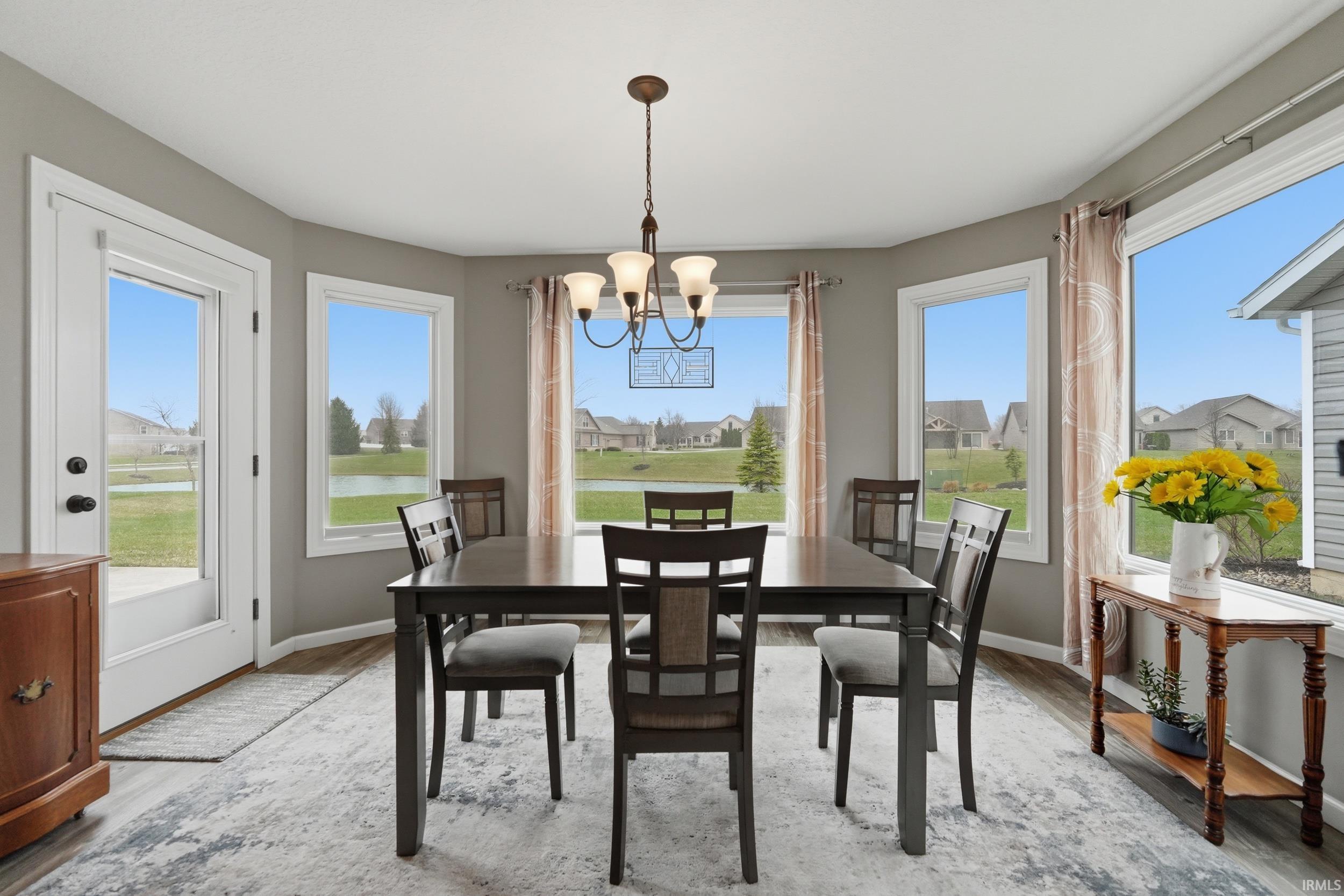 Dining area with suspended lighting, wood finished floors, and plenty of natural light