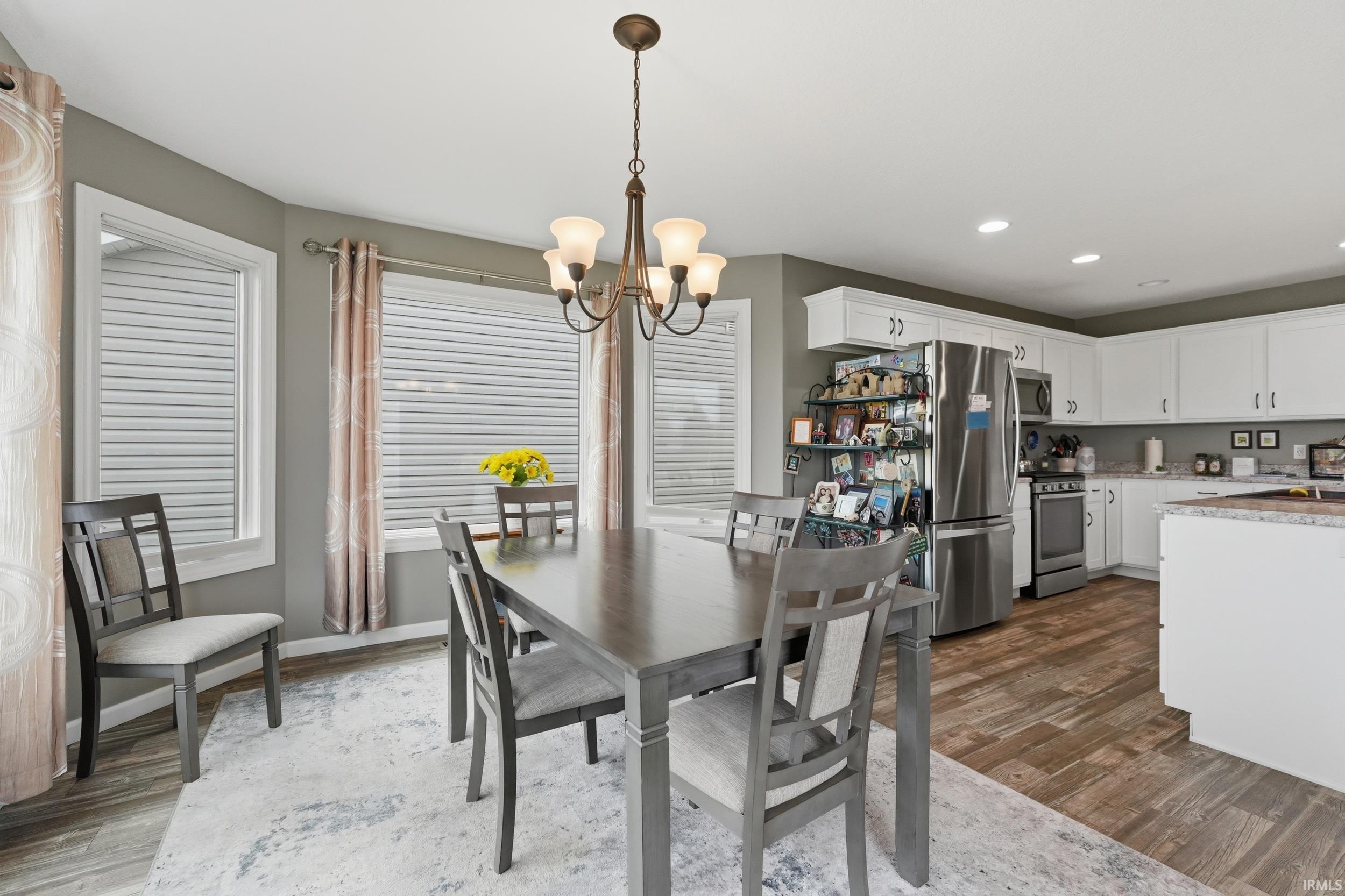 Dining space featuring suspended lighting and dark wood-type flooring