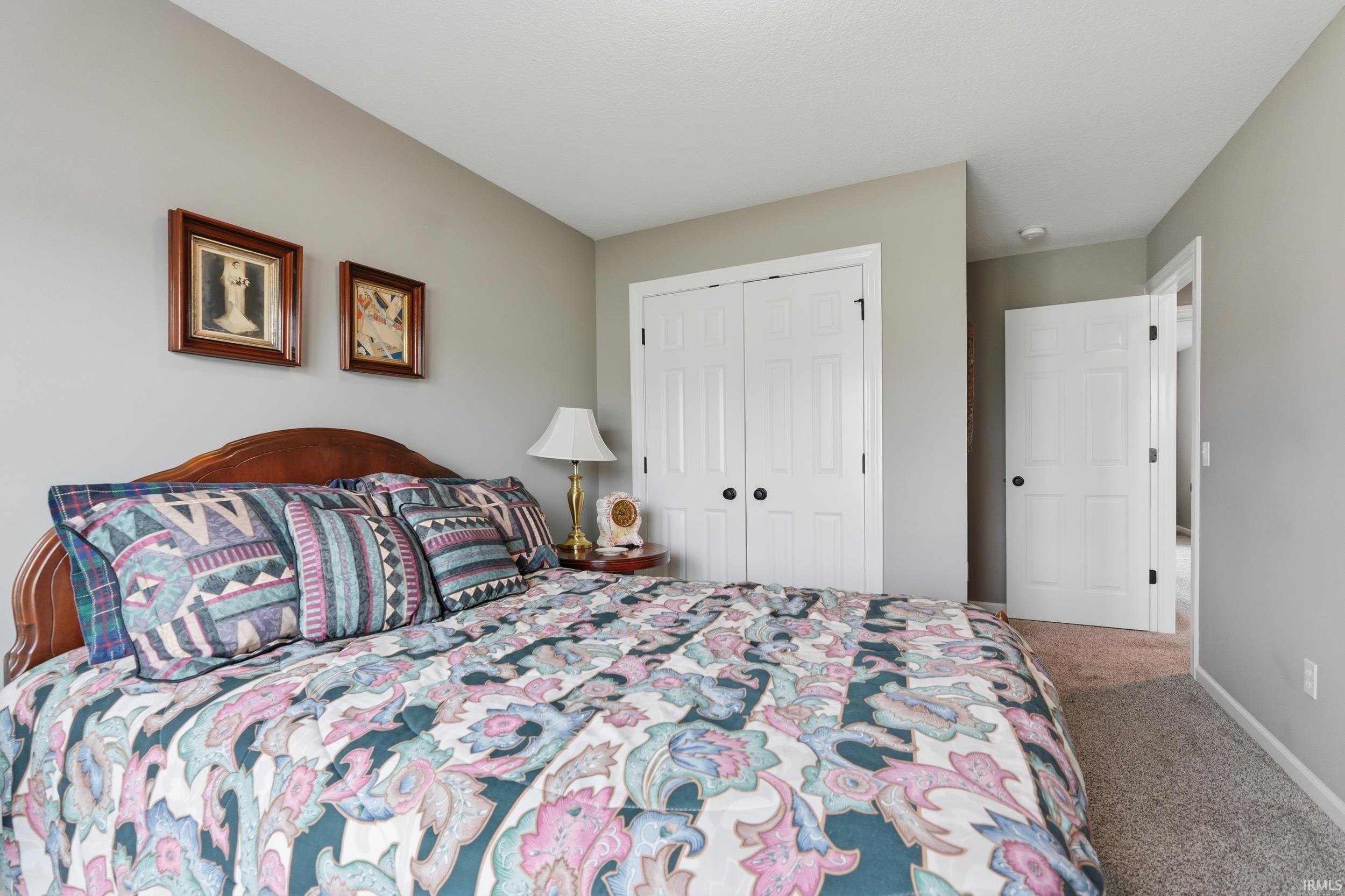 Carpeted bedroom with a closet and baseboards