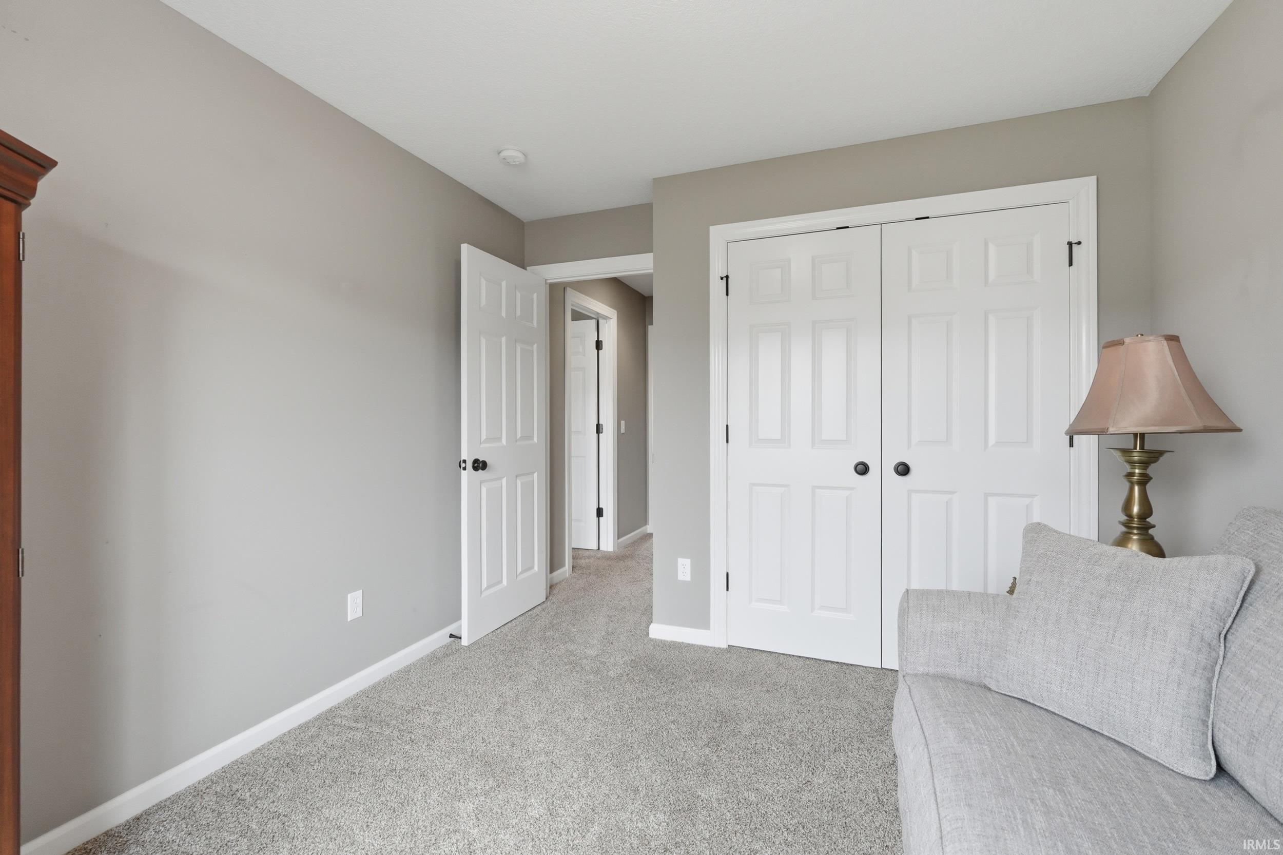 Sitting room with light colored carpet and baseboards