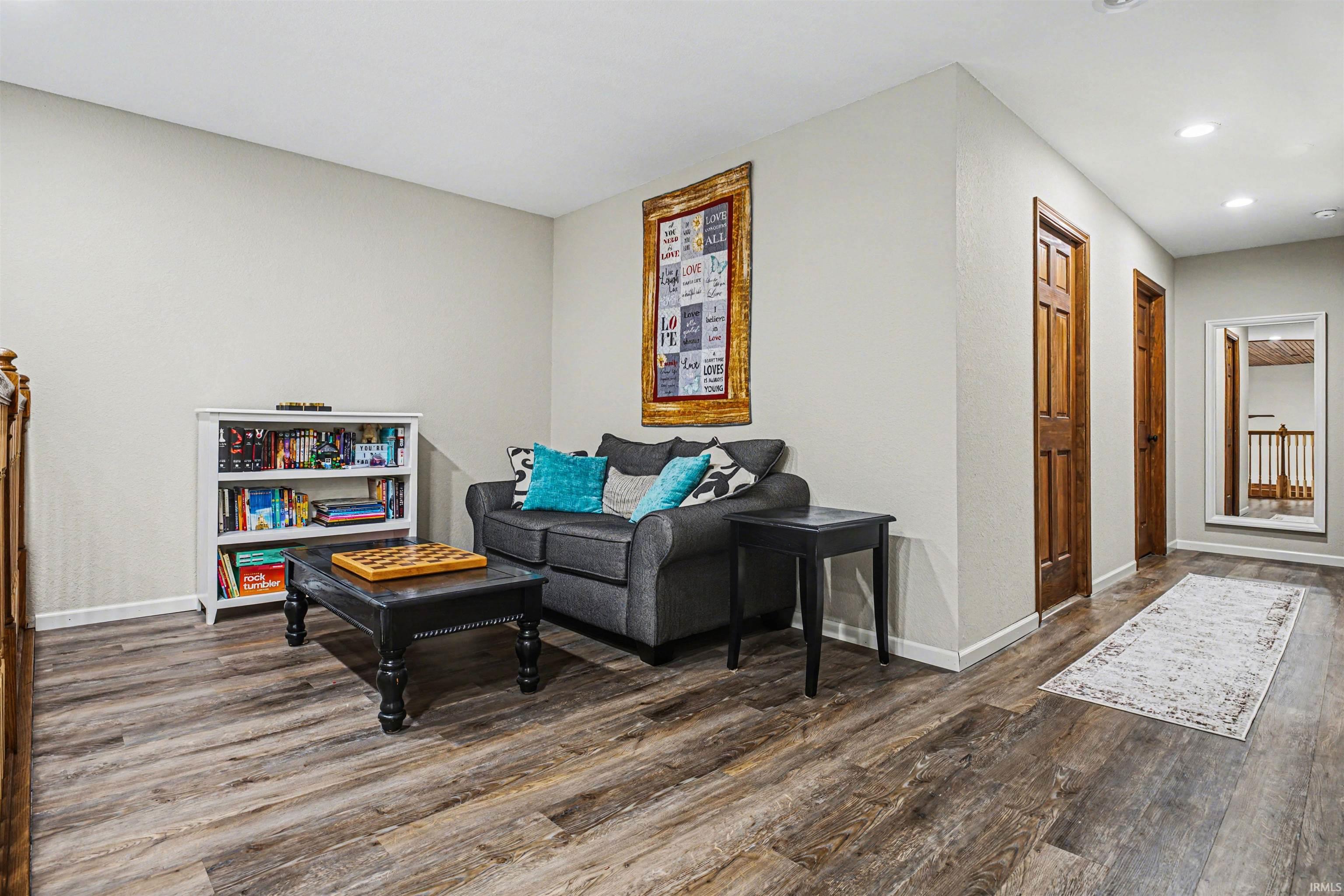 Living area featuring dark wood-style flooring and recessed lighting