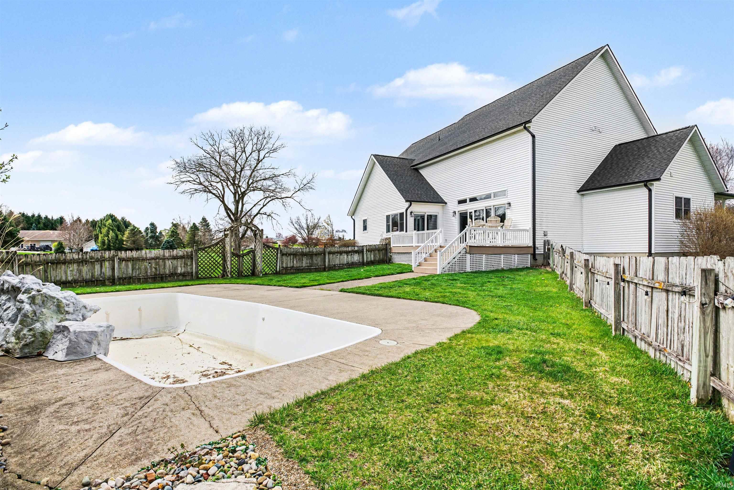 Back of house with a fenced backyard, a patio area, a wooden deck, and a shingled roof