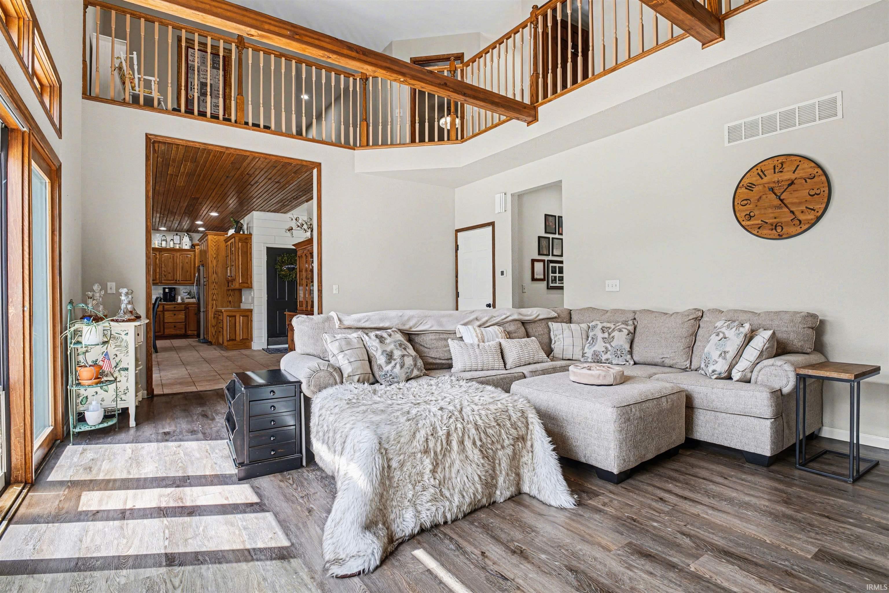 Living room featuring wood finished floors and a high ceiling