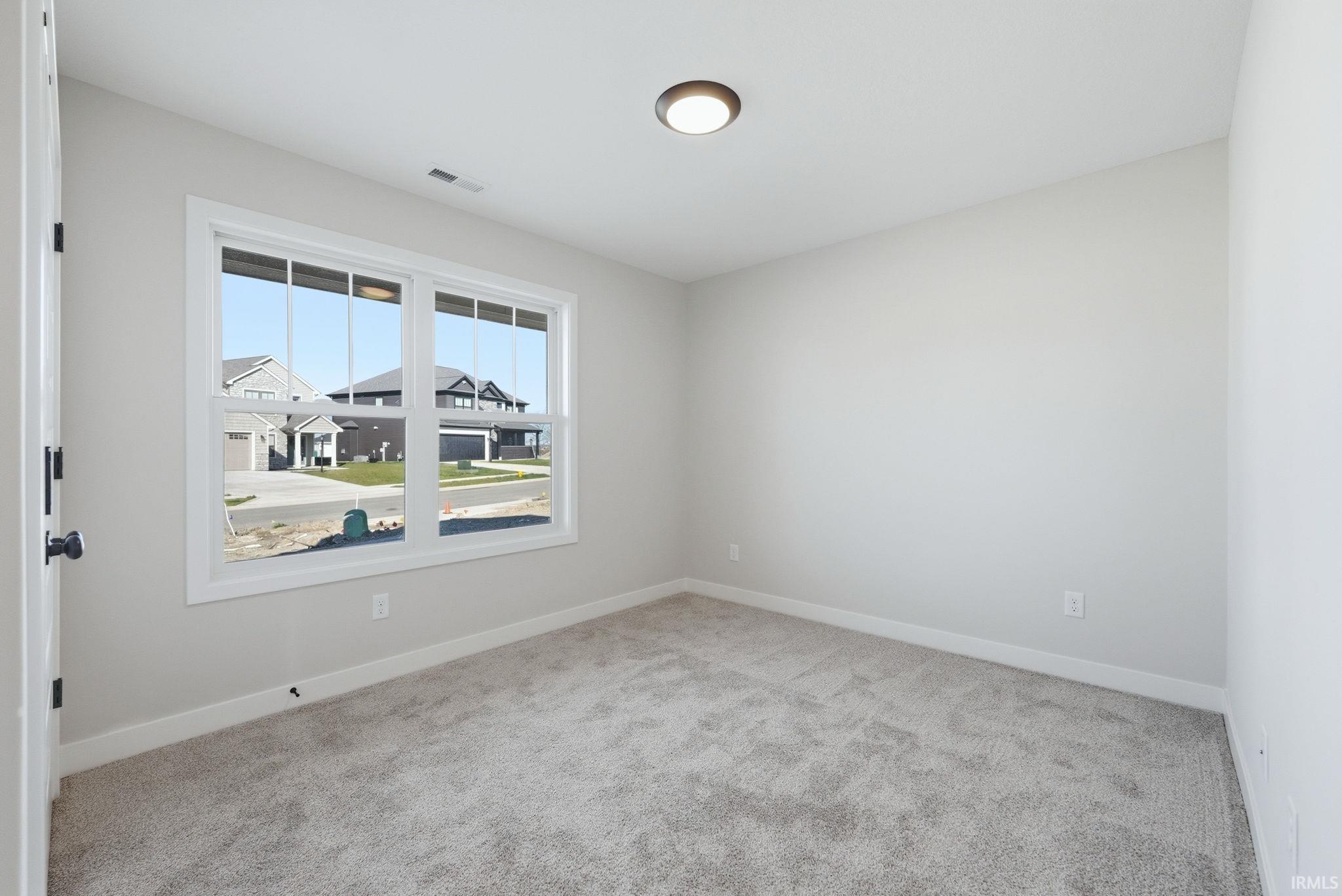 Spare room with light carpet and baseboards