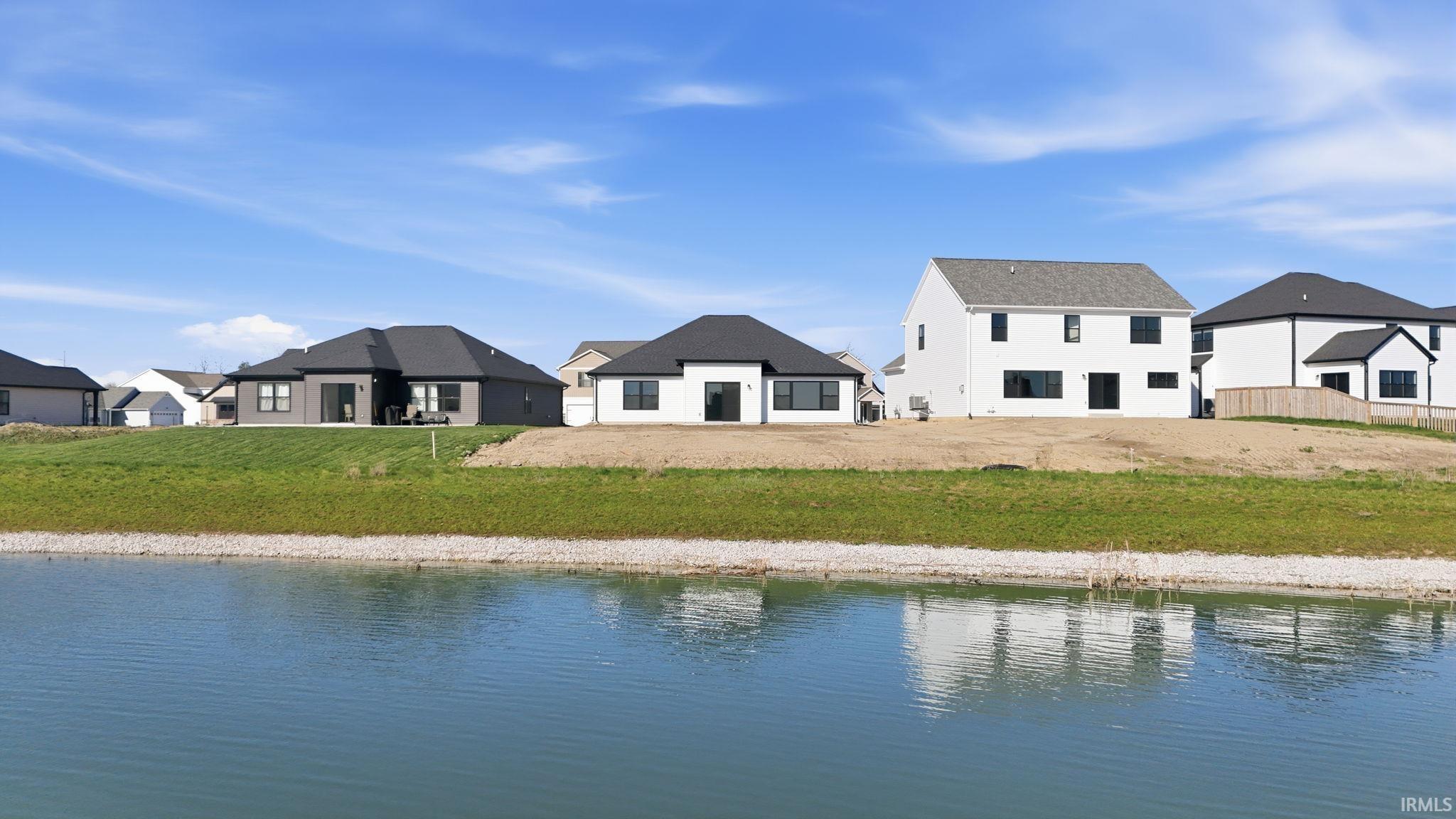 Rear view of house with a water view and a residential view
