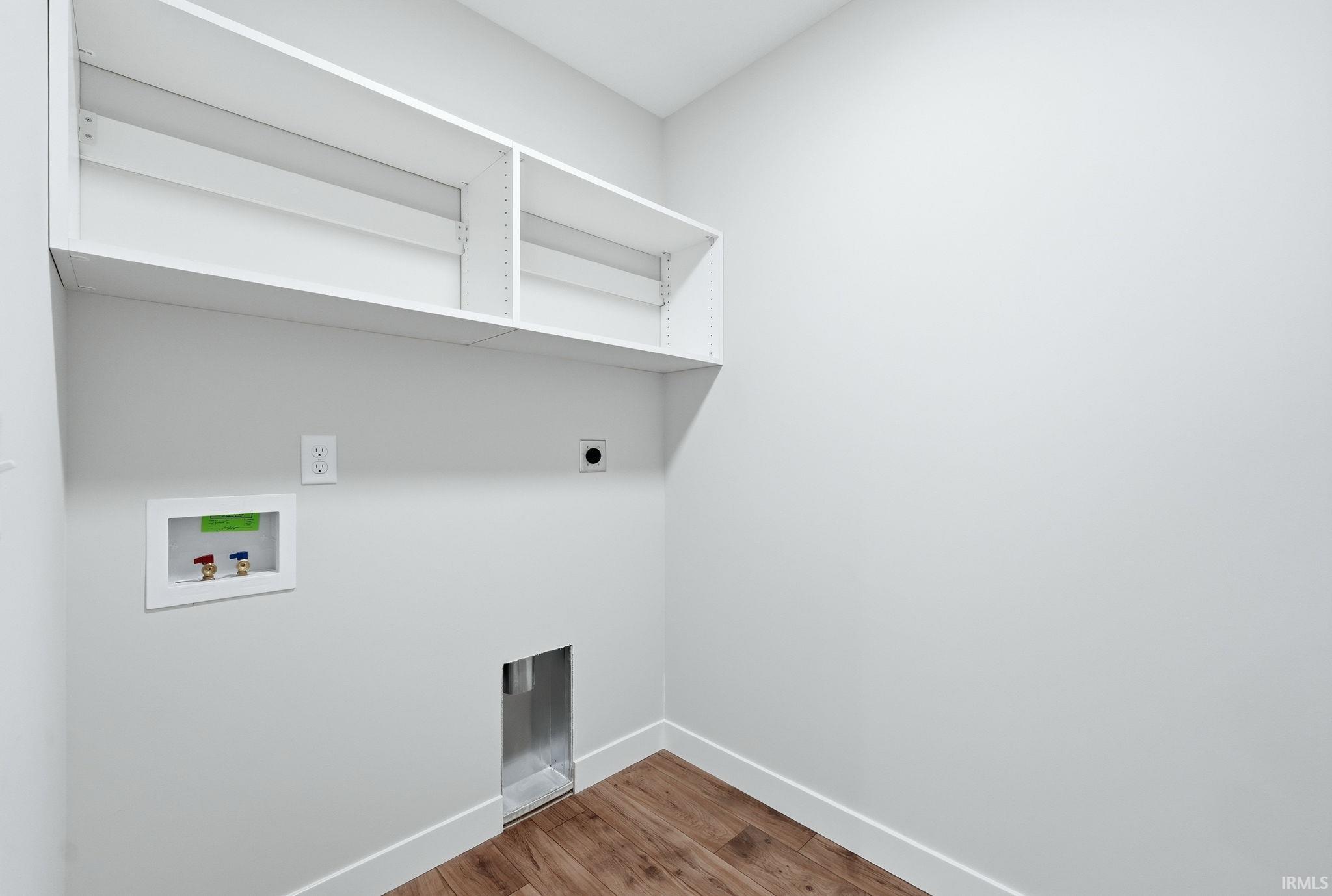 Laundry room with light wood finished floors, hookup for a washing machine, and hookup for an electric dryer