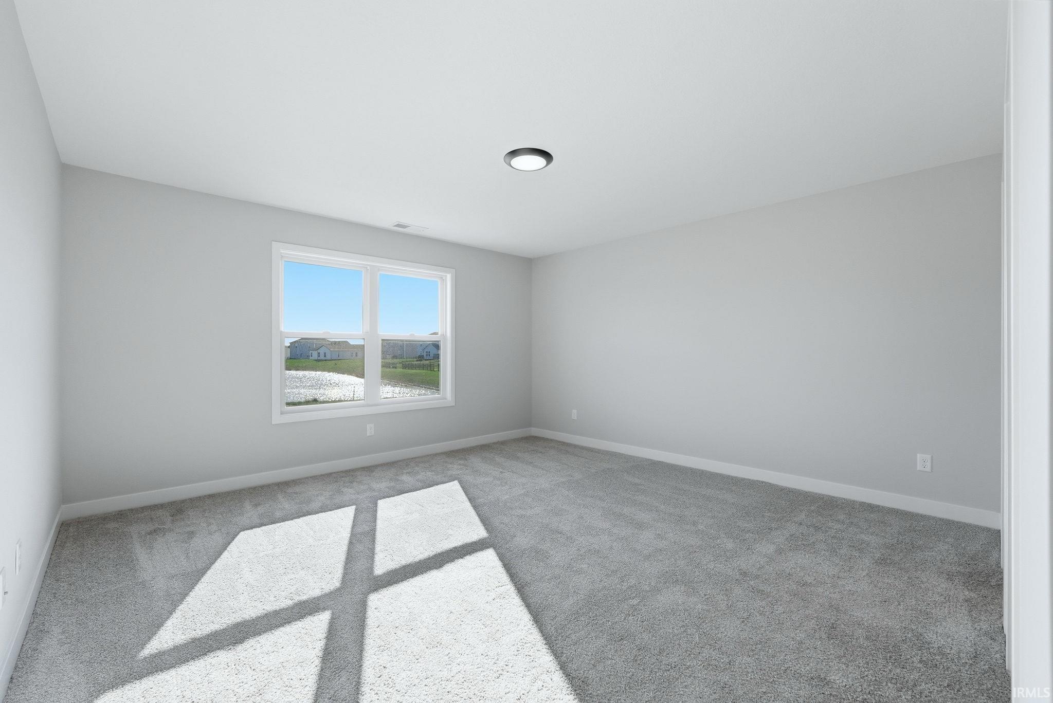 Unfurnished room featuring light carpet and baseboards