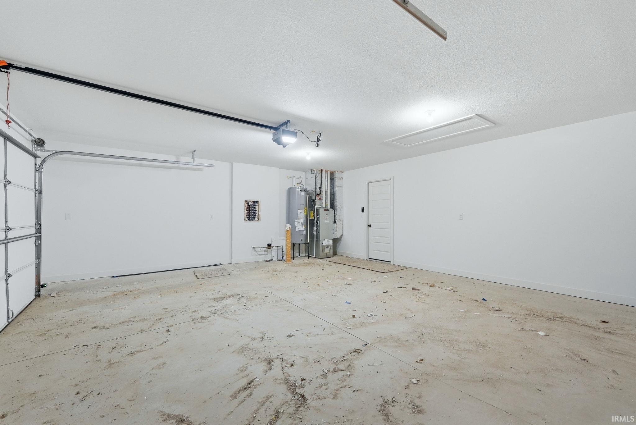 Garage featuring water heater and baseboards