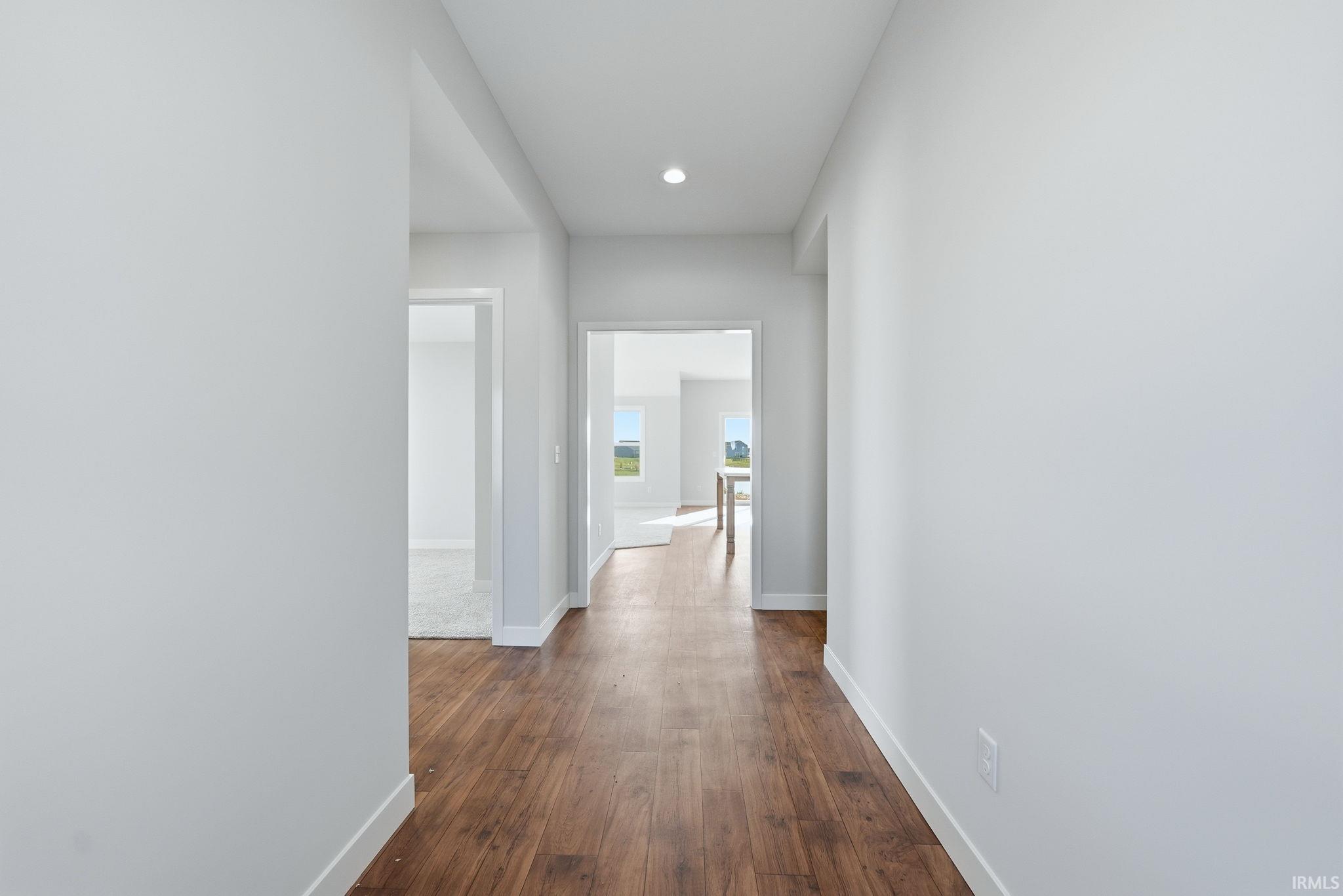 Hall featuring dark wood-type flooring and recessed lighting