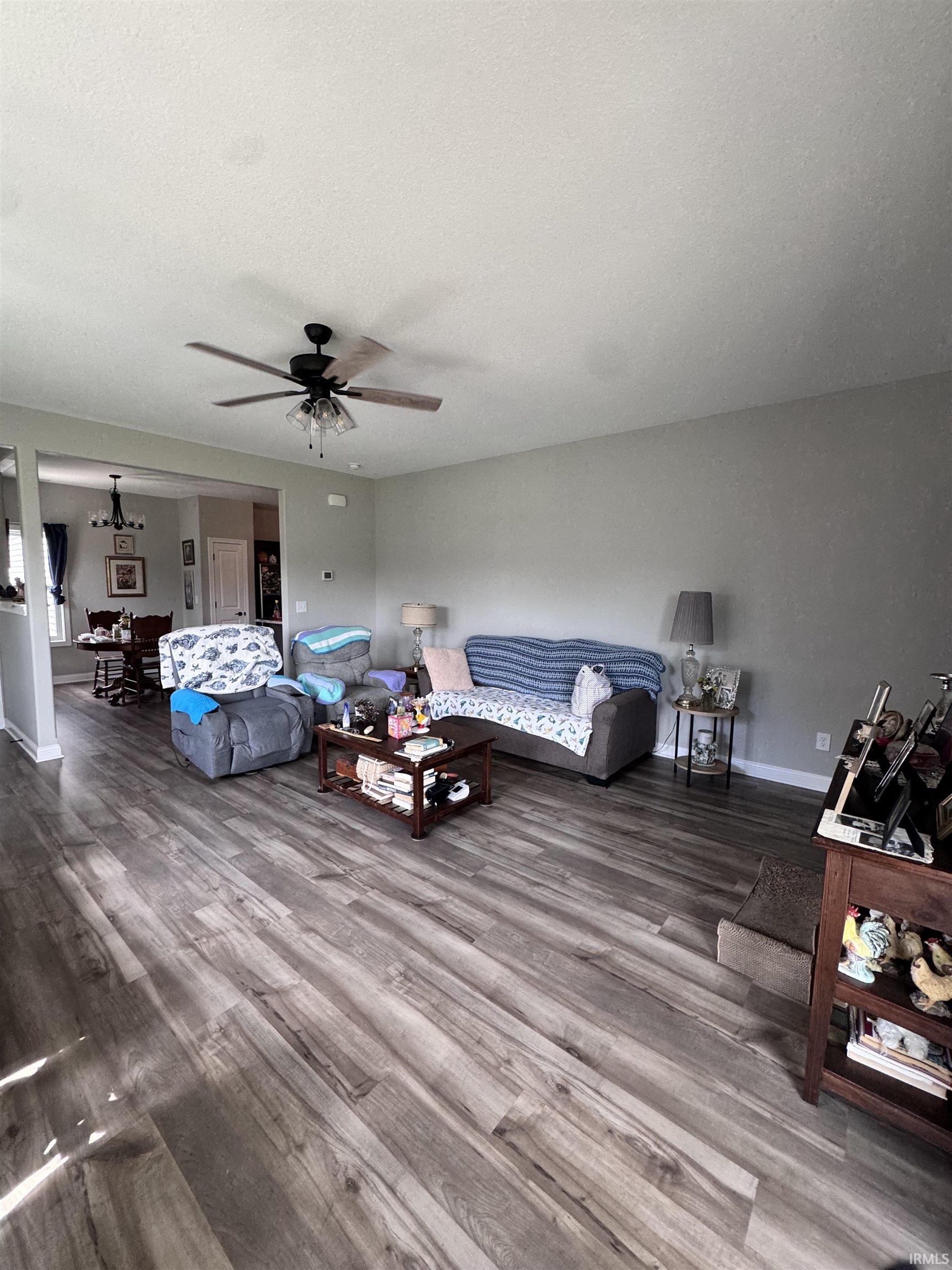 Living area with wood finished floors, ceiling fan, and a textured ceiling