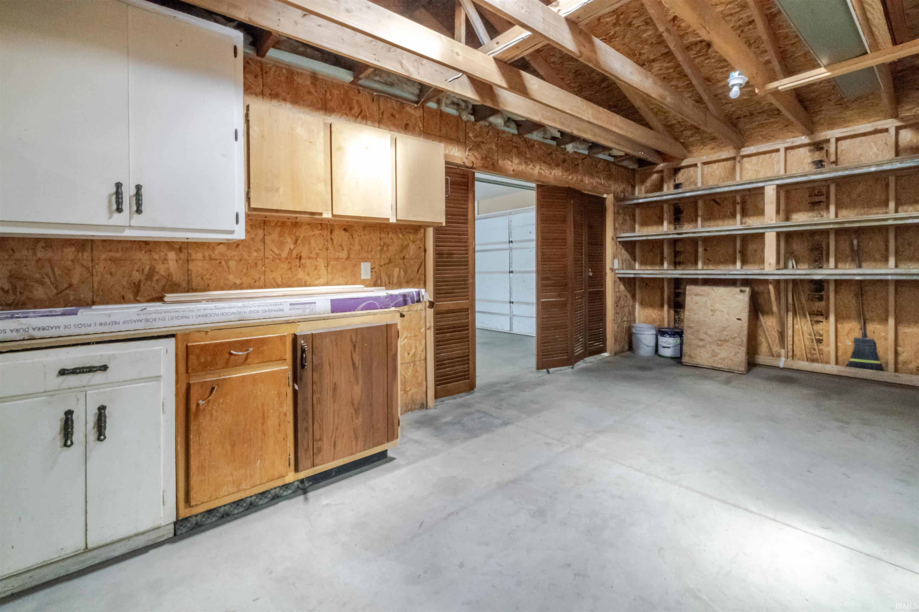 Kitchen with unfinished concrete floors, light countertops, and dual tone cabinets