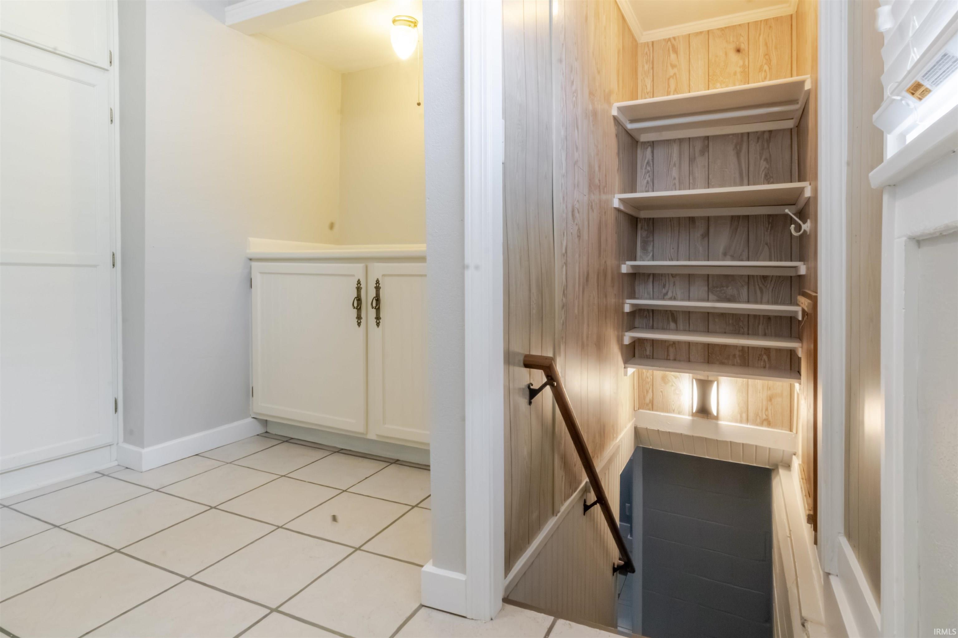 Stairway featuring tile patterned flooring and ornamental molding