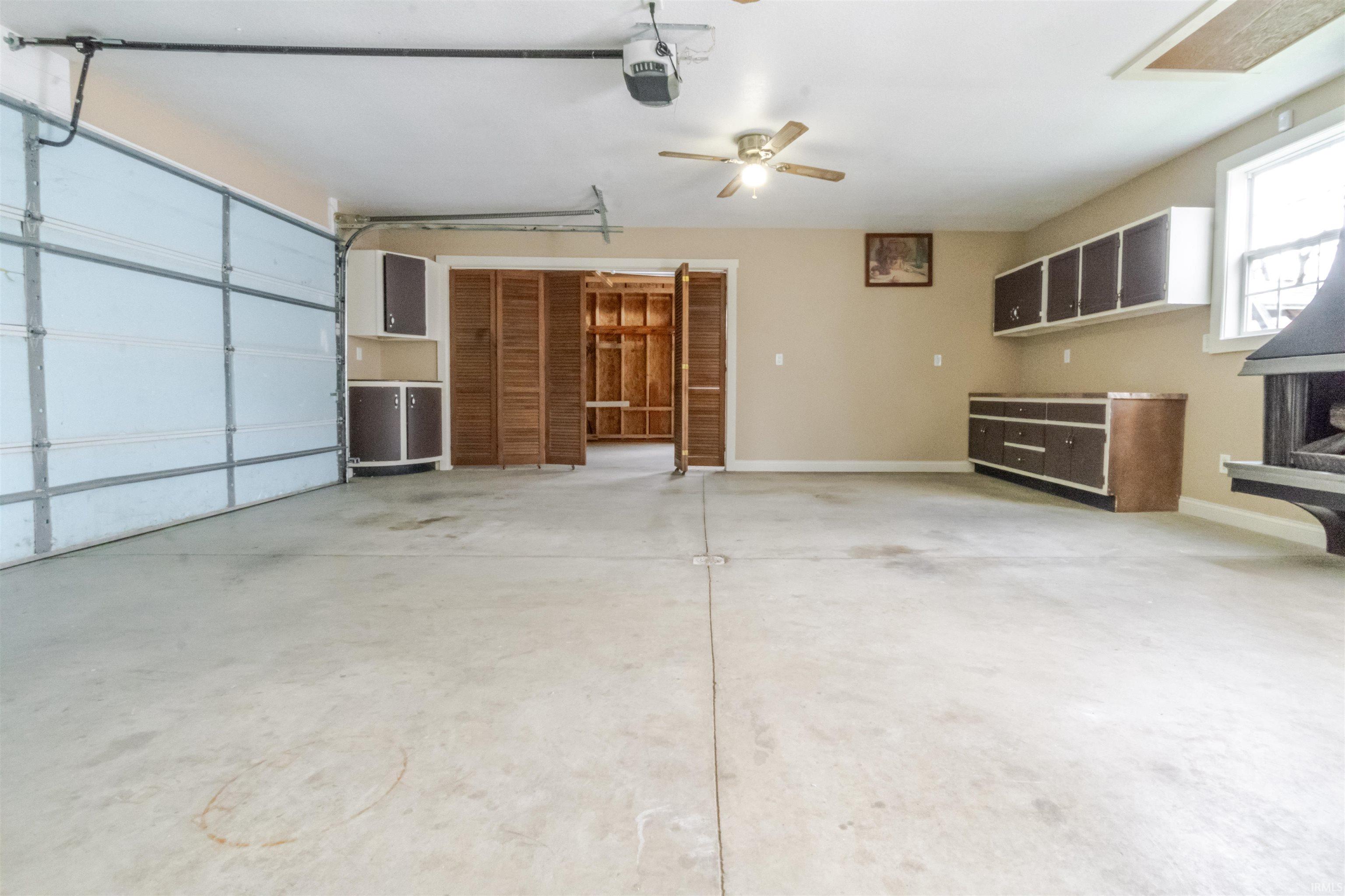 Garage featuring ceiling fan and a garage door opener