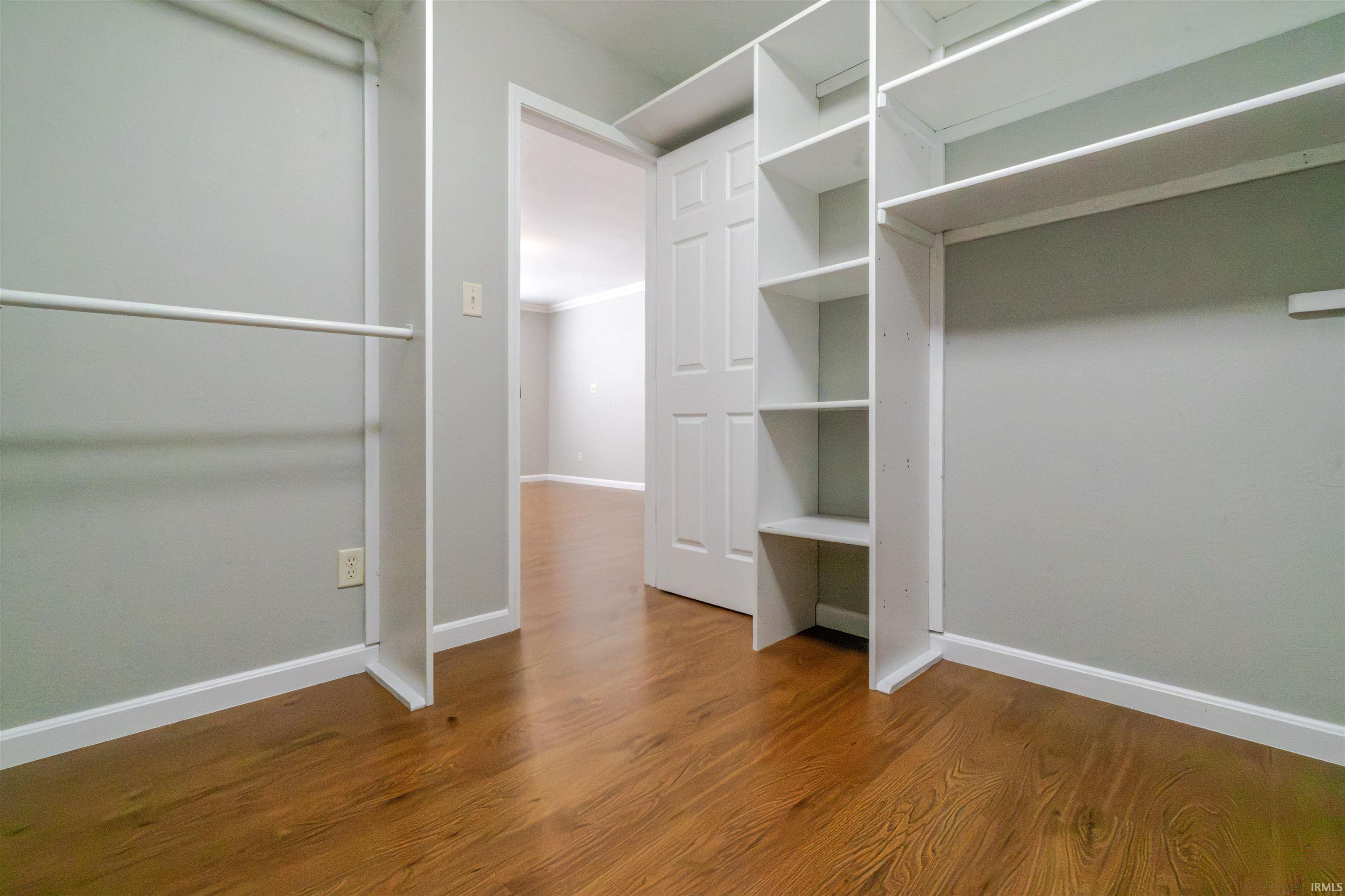 Walk in closet featuring dark wood finished floors