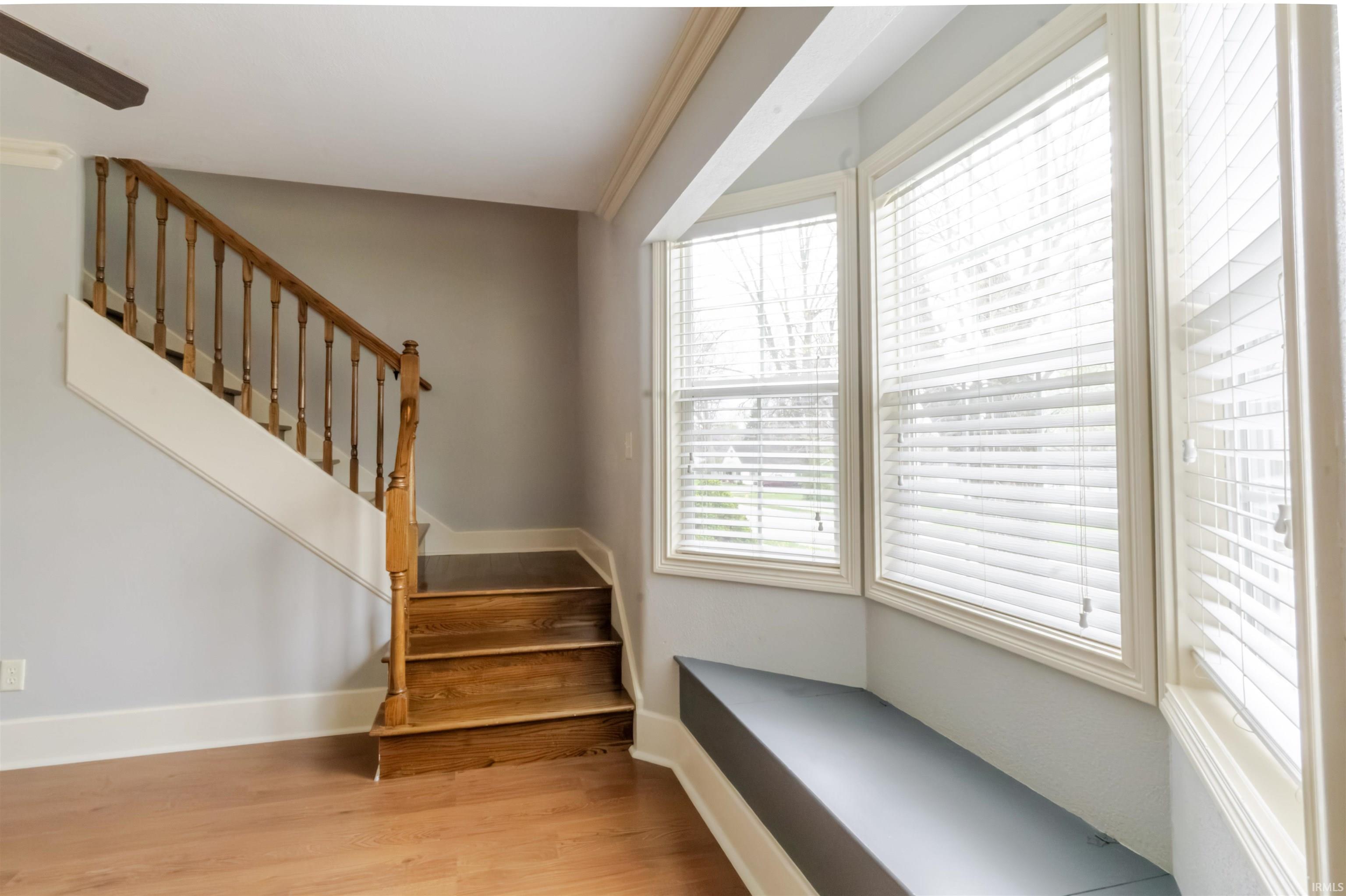 Staircase with wood finished floors and baseboards
