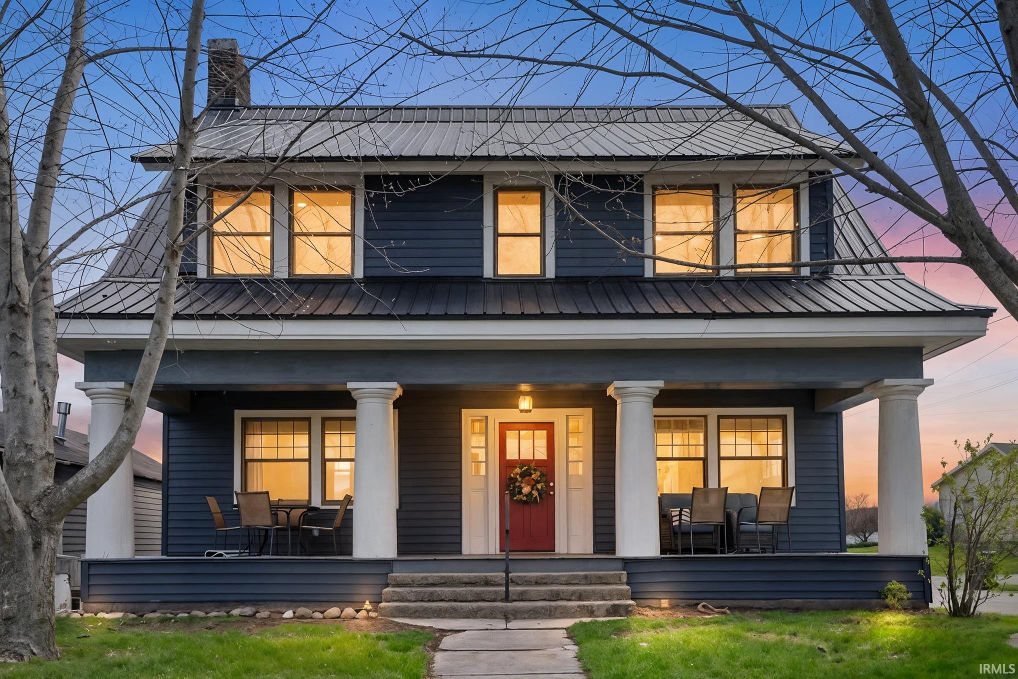 View of front of house with covered porch and a chimney