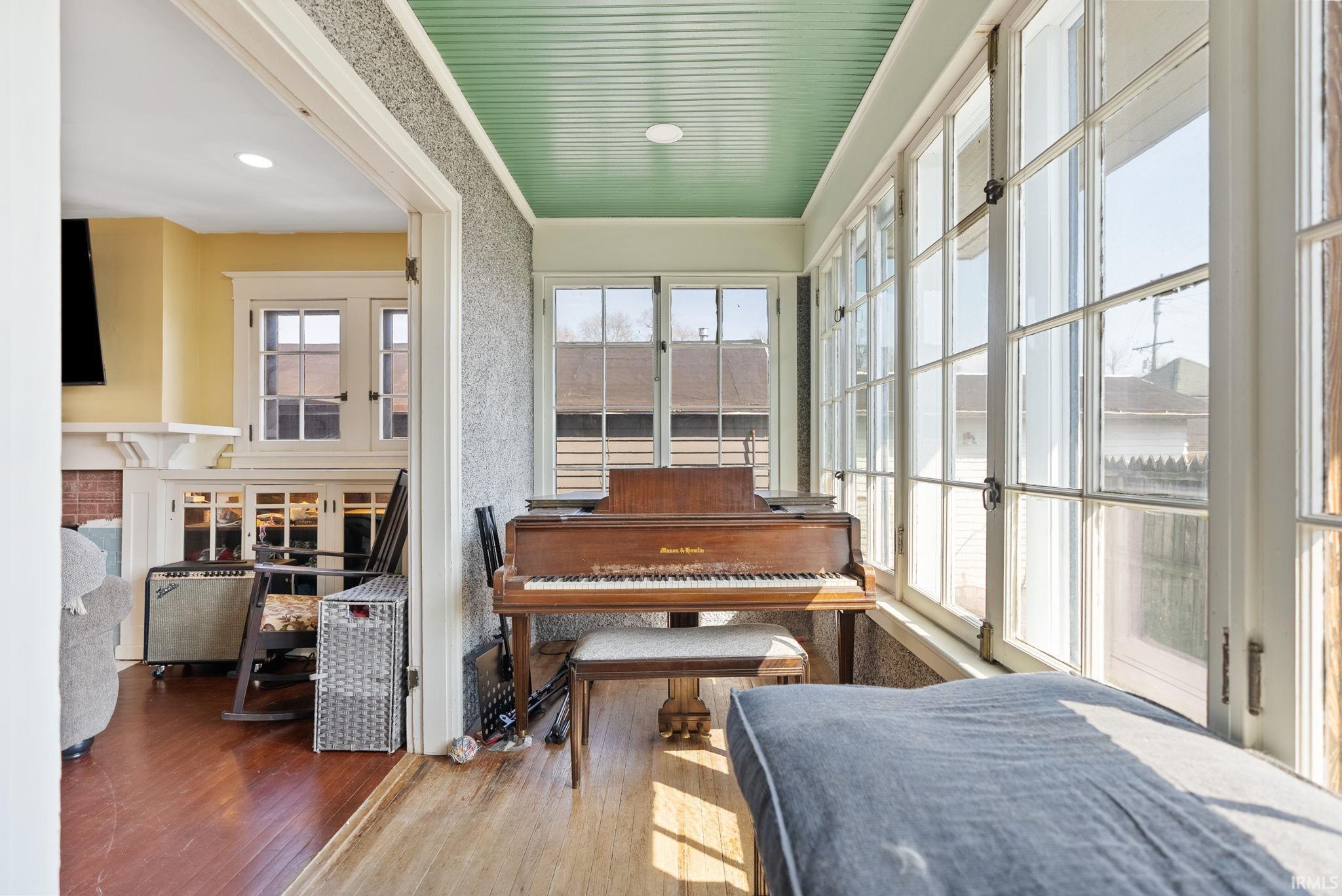 Sunroom featuring wood-type flooring and french doors