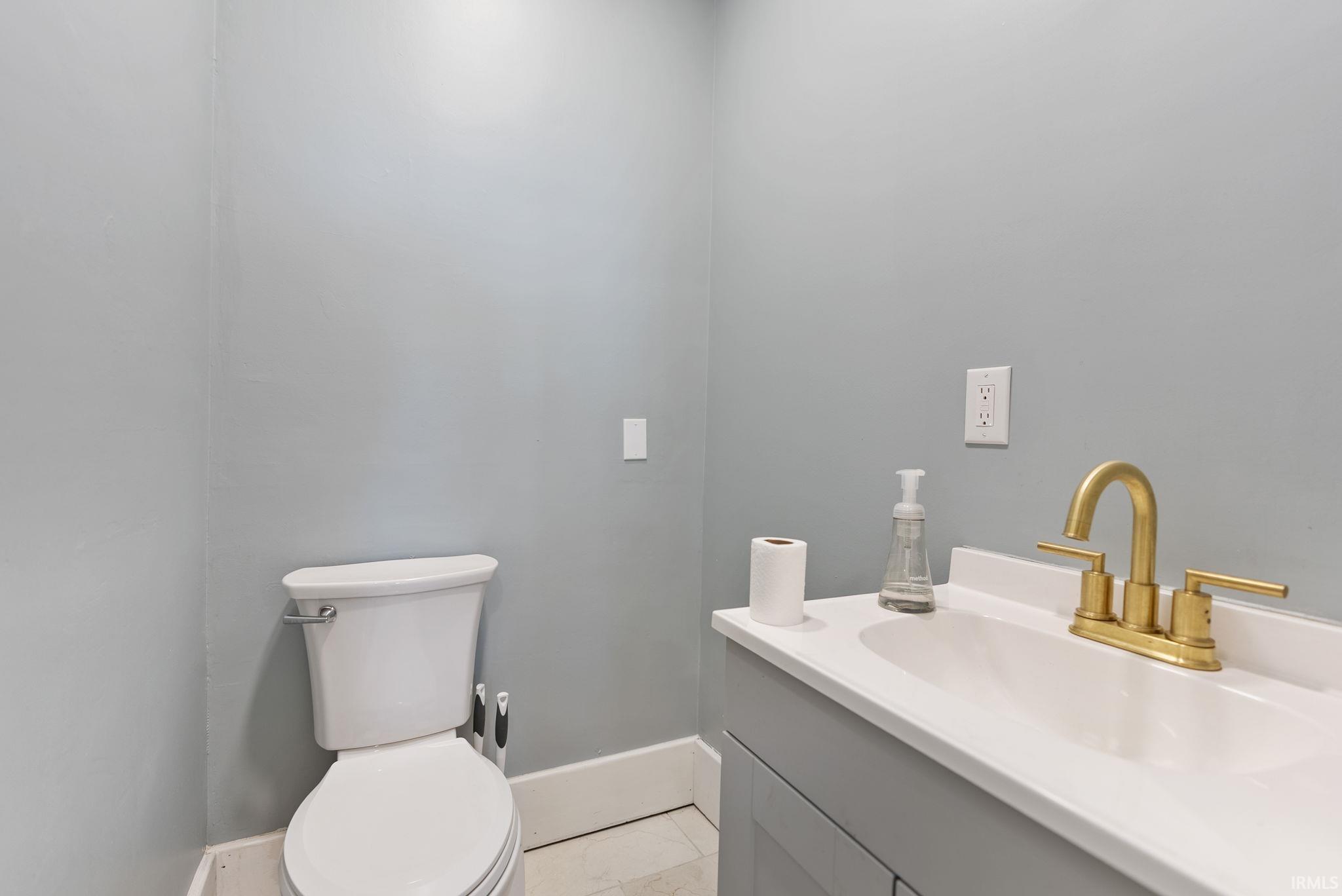 Half bath featuring vanity and light tile patterned floors