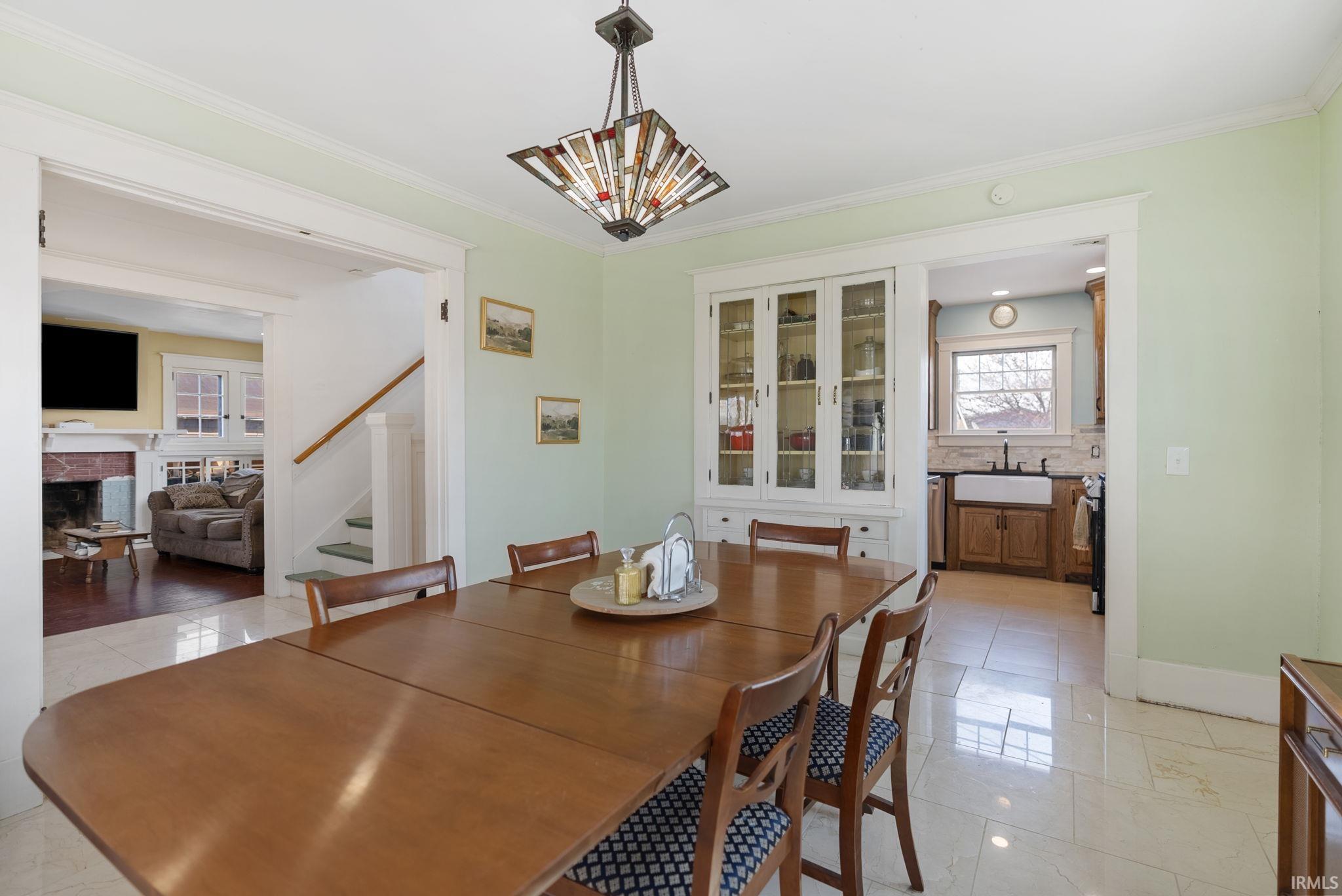 Dining area featuring ornamental molding and a fireplace