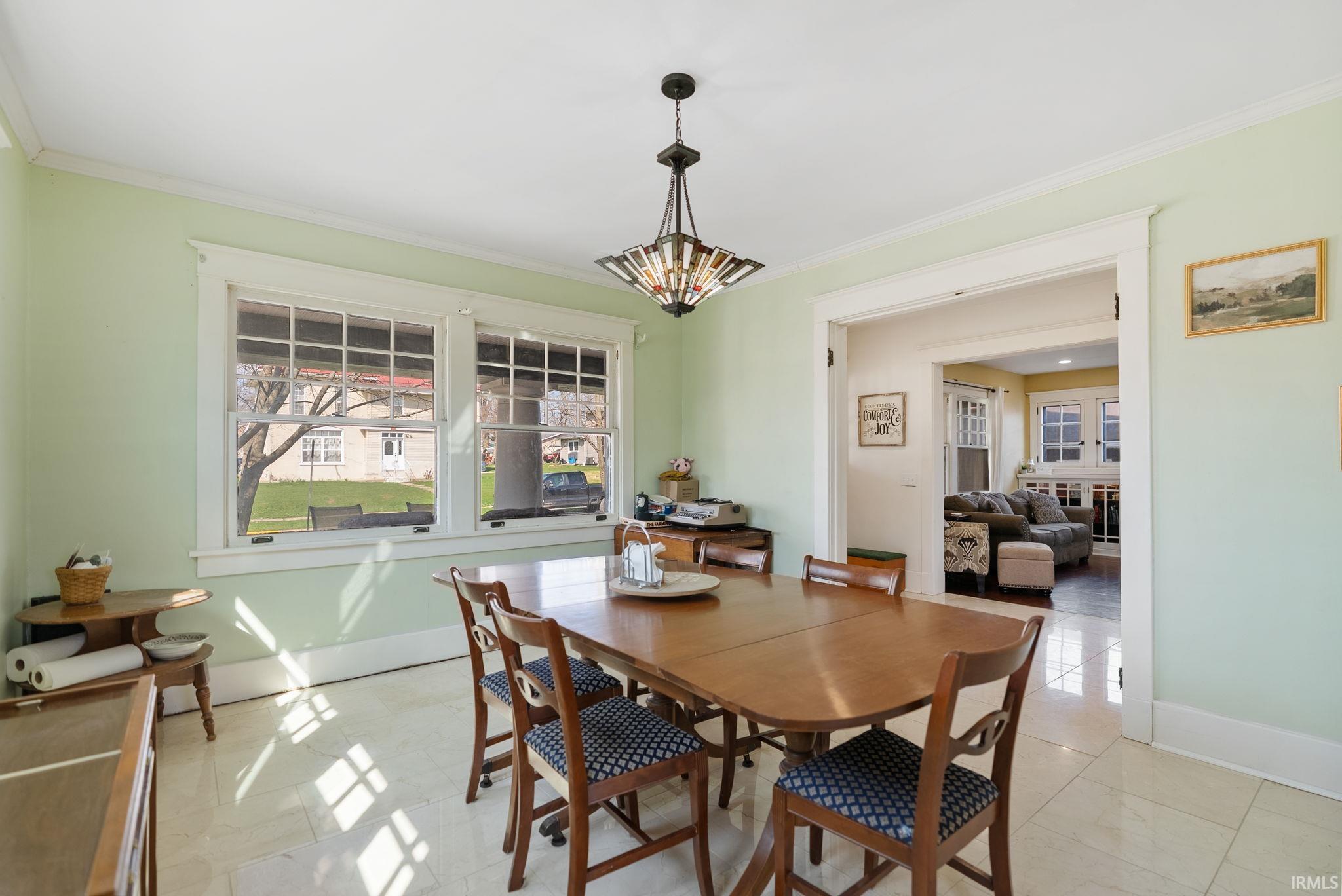 Dining space with healthy amount of natural light and crown molding
