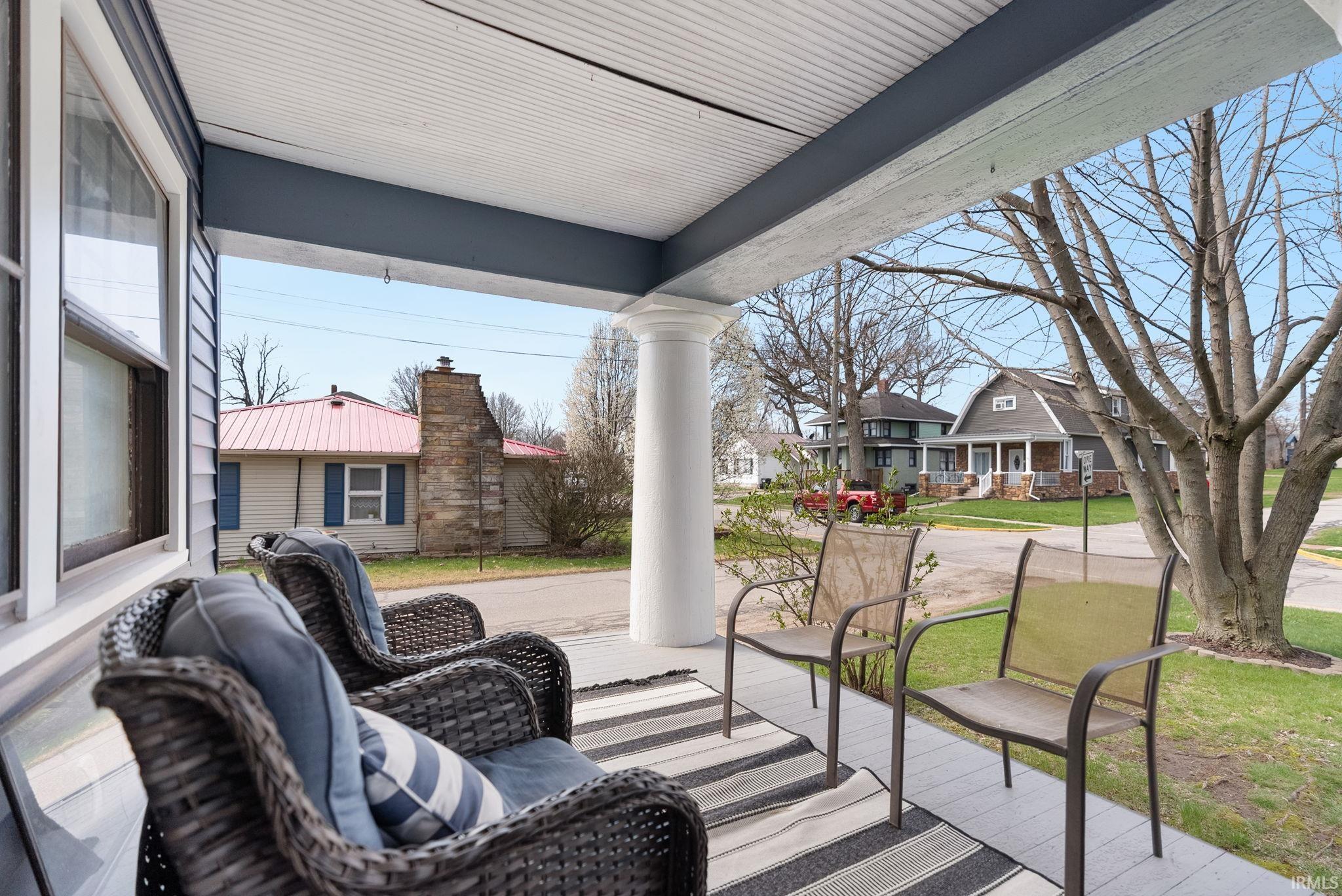 Porch with a residential view and a lawn