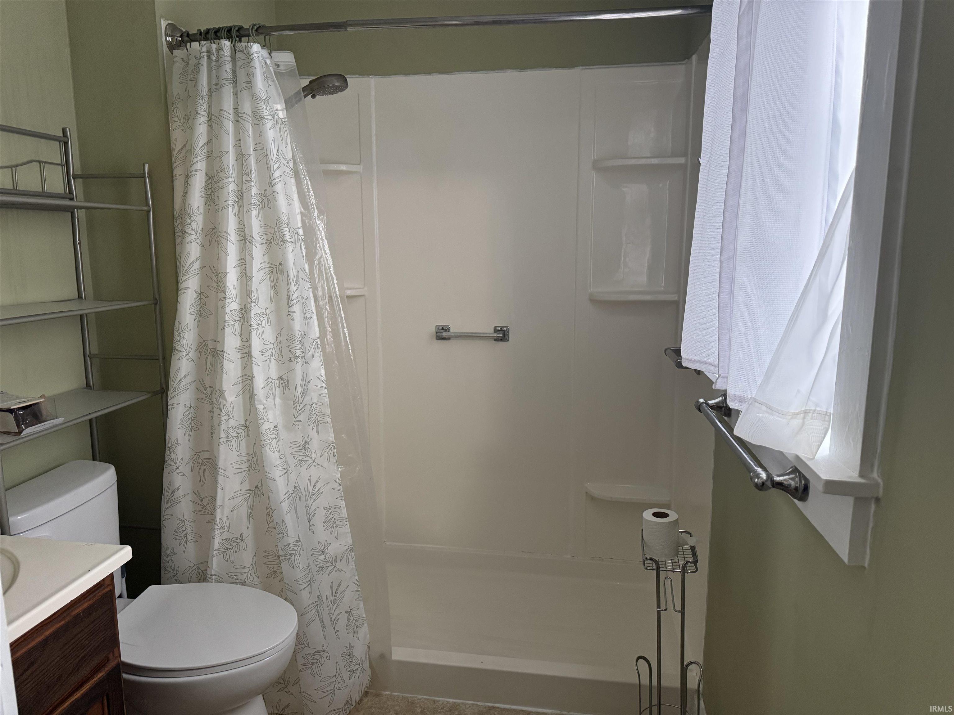 Bathroom featuring a shower stall and vanity