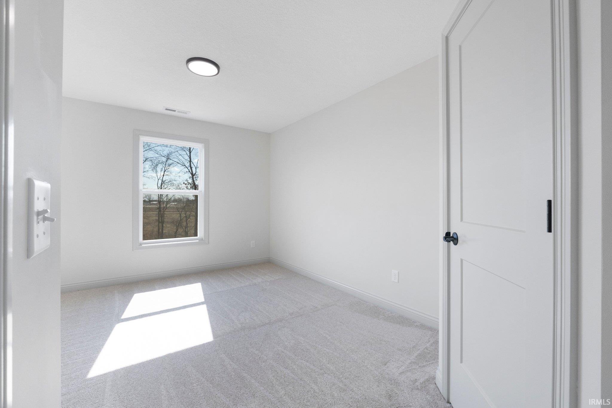 Neutral-toned room with light gray carpeting and white walls