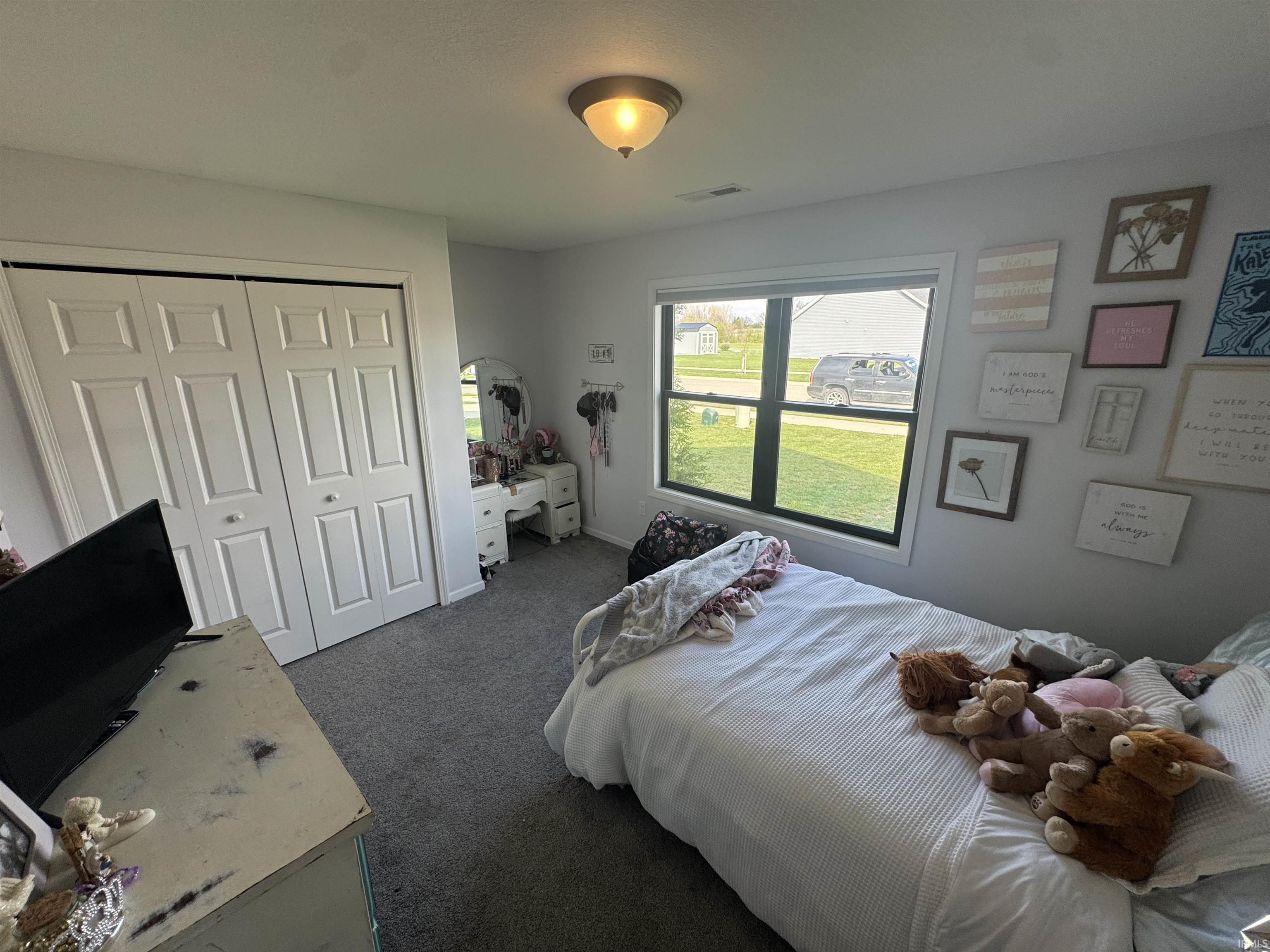 Bedroom featuring dark colored carpet and a closet