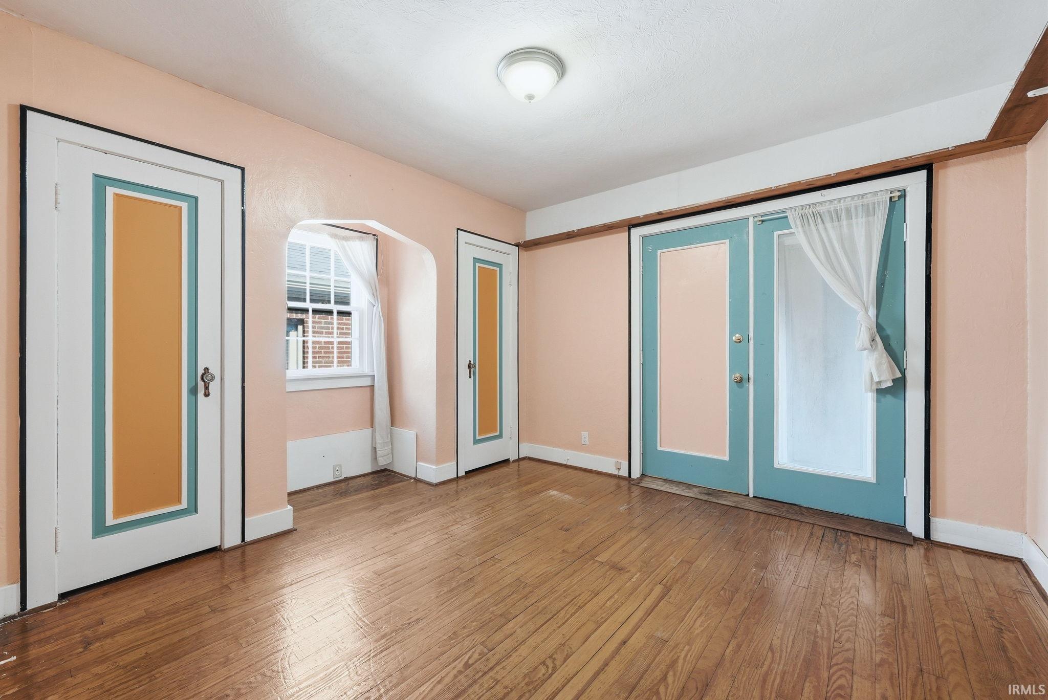 Unfurnished room featuring french doors and light wood-type flooring