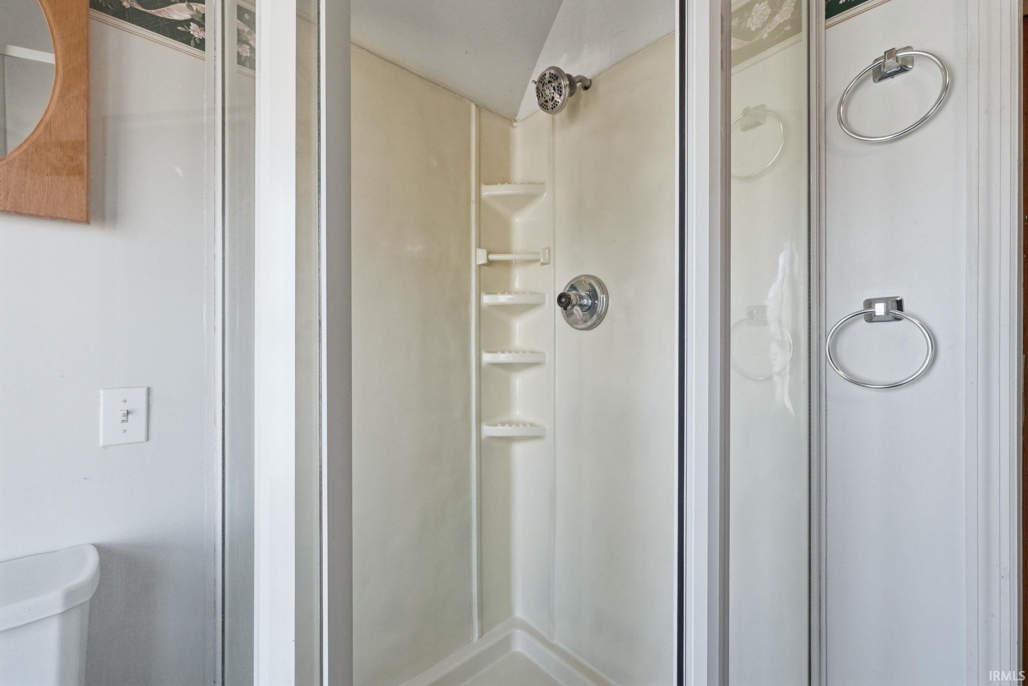 Bathroom featuring a shower stall and toilet