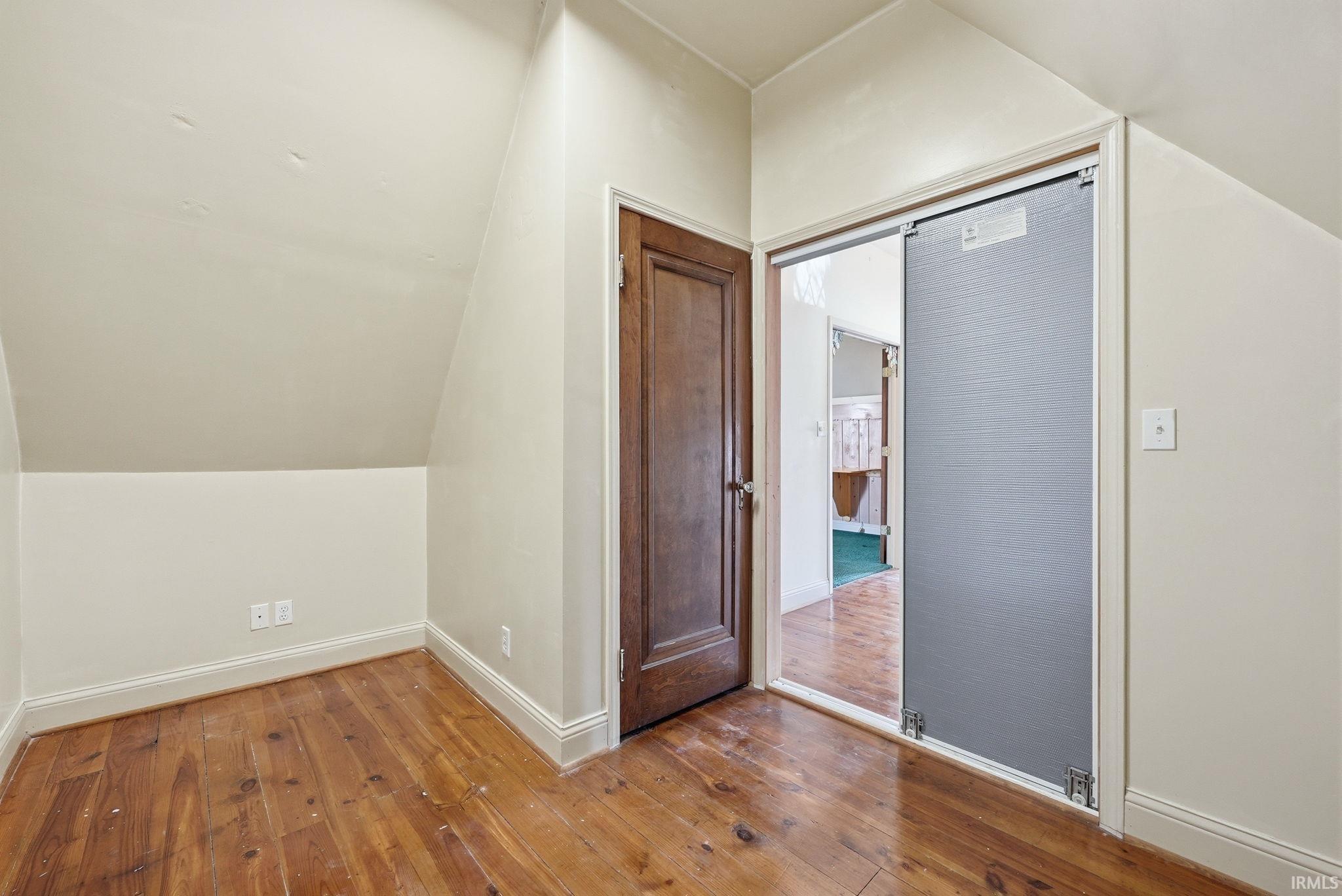 Bonus room featuring lofted ceiling and hardwood / wood-style flooring