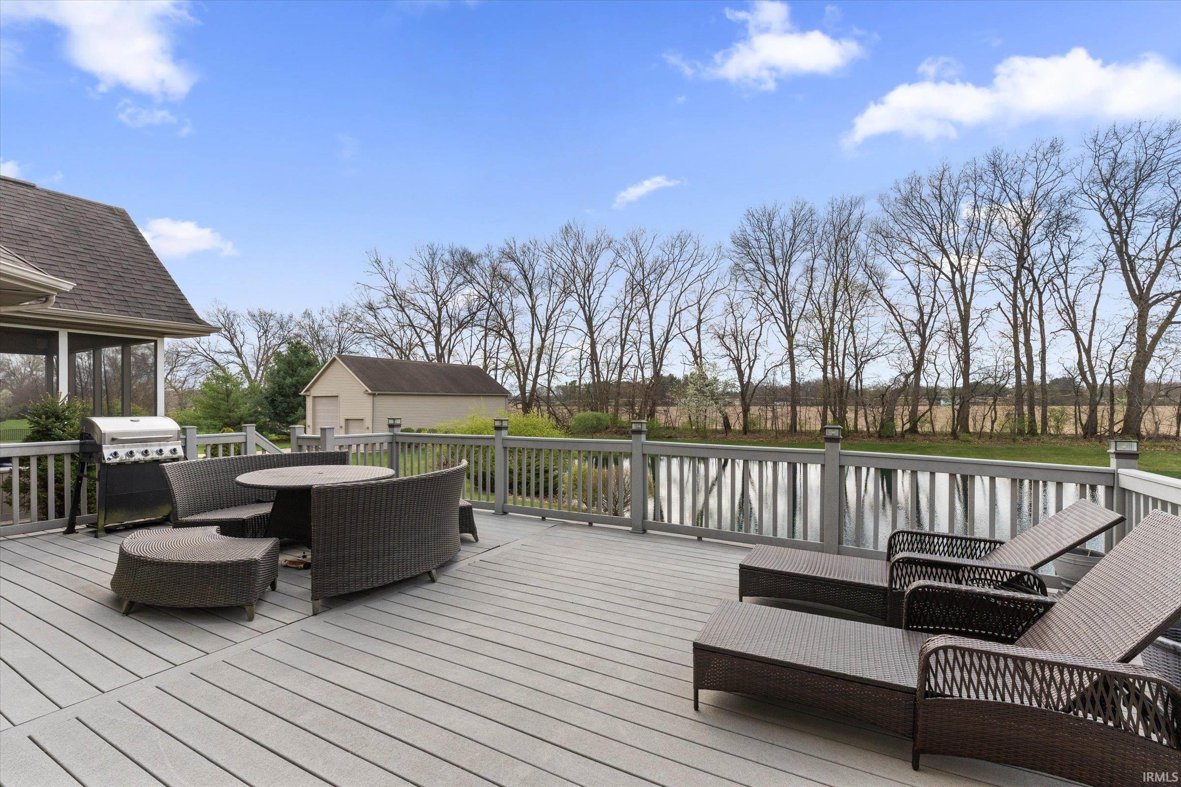 Wooden terrace with a grill, outdoor lounge area, and a sunroom