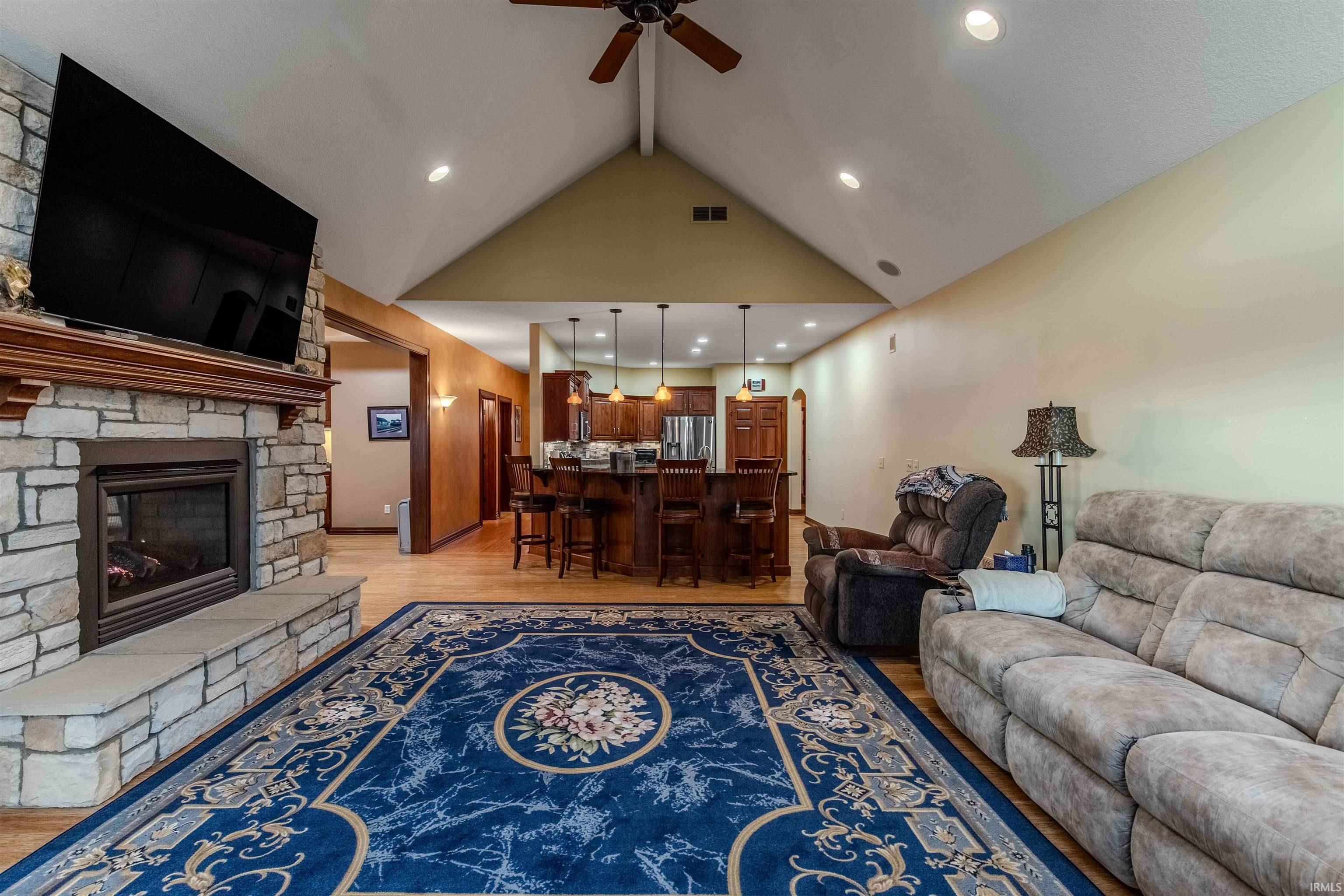 Living room featuring a custom fireplace, Bamboo floors, vaulted ceilings, and recessed lighting