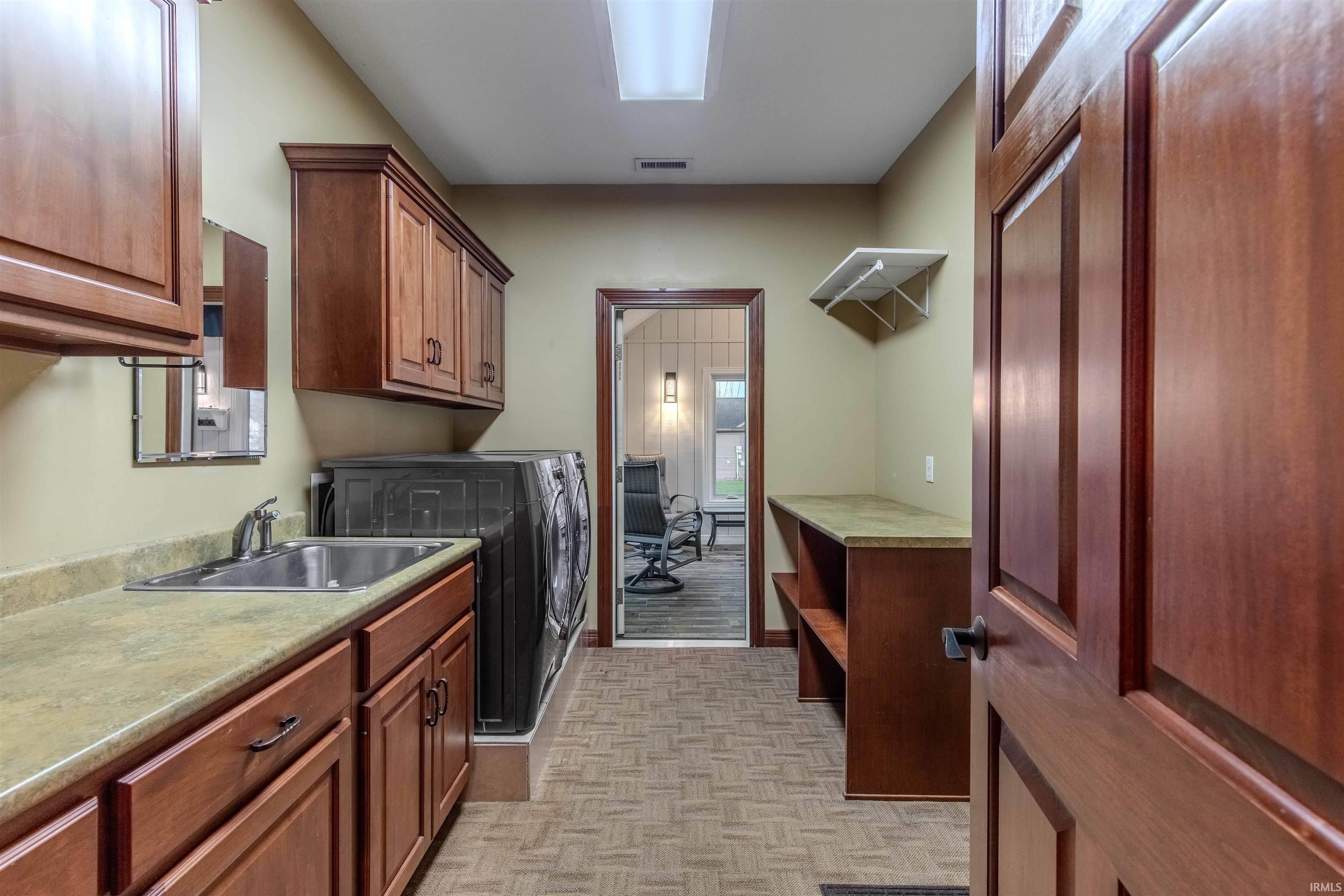 Custom Laundry area with custom cabs., drop down ironing board and lots of extra storage.