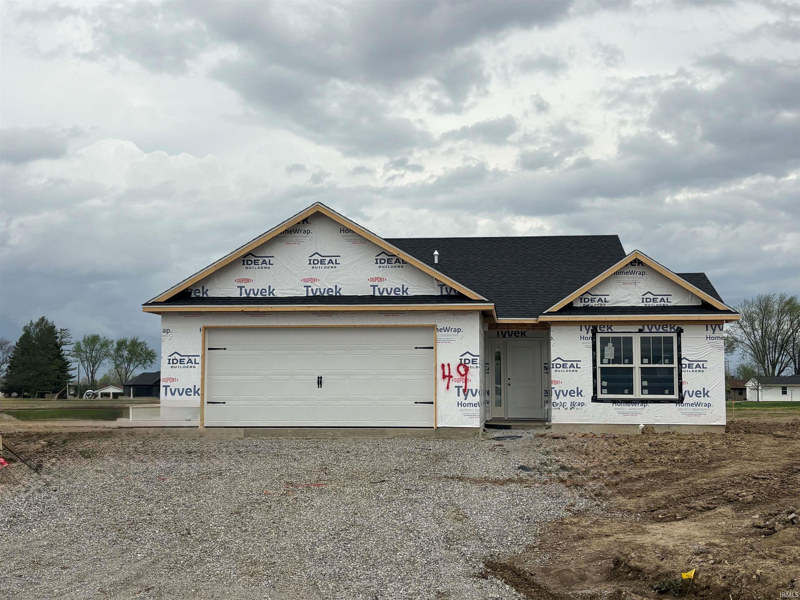 Property under construction featuring gravel driveway and an attached garage