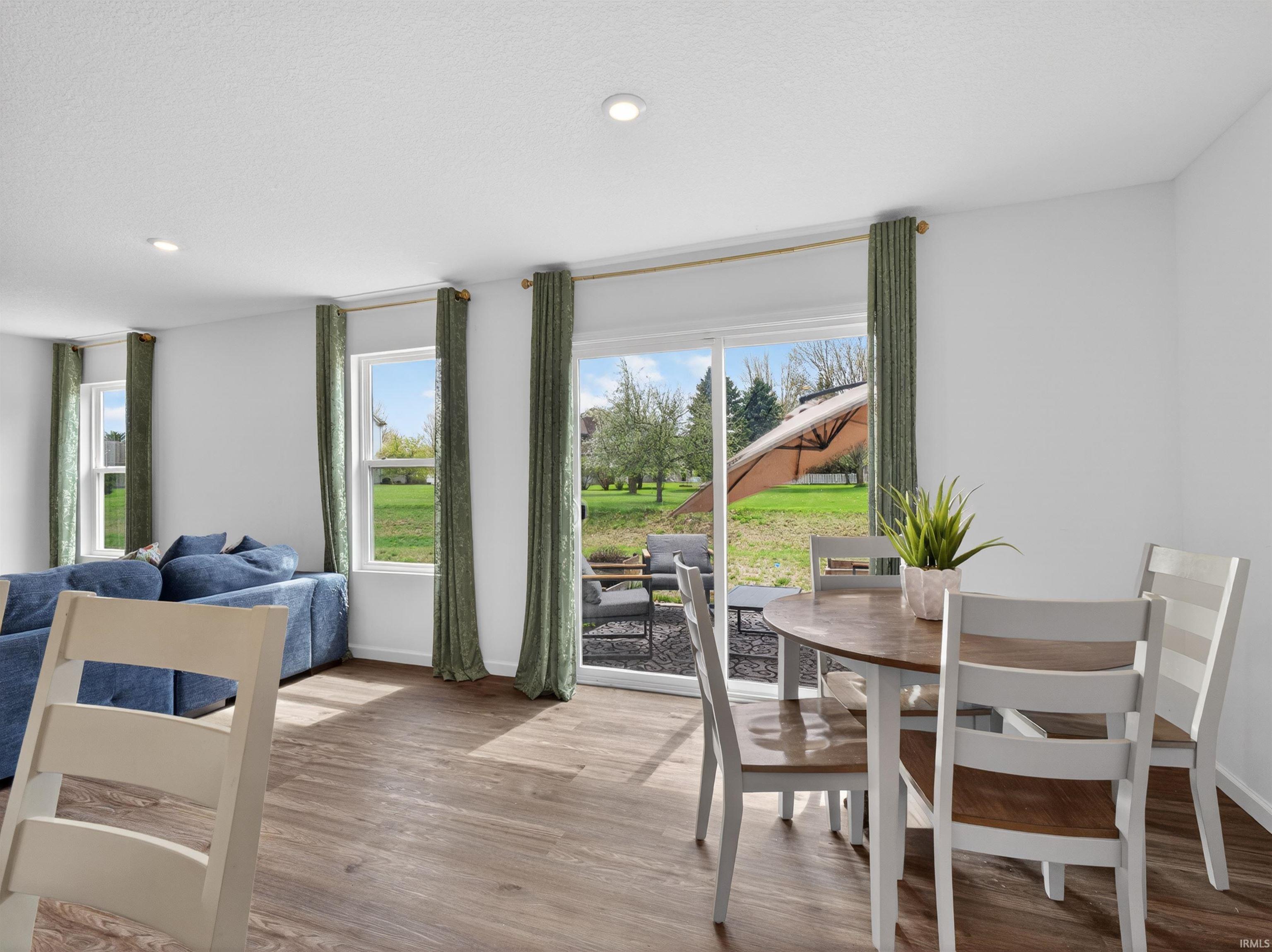 Dining room featuring light wood-style floors, plenty of natural light, and recessed lighting