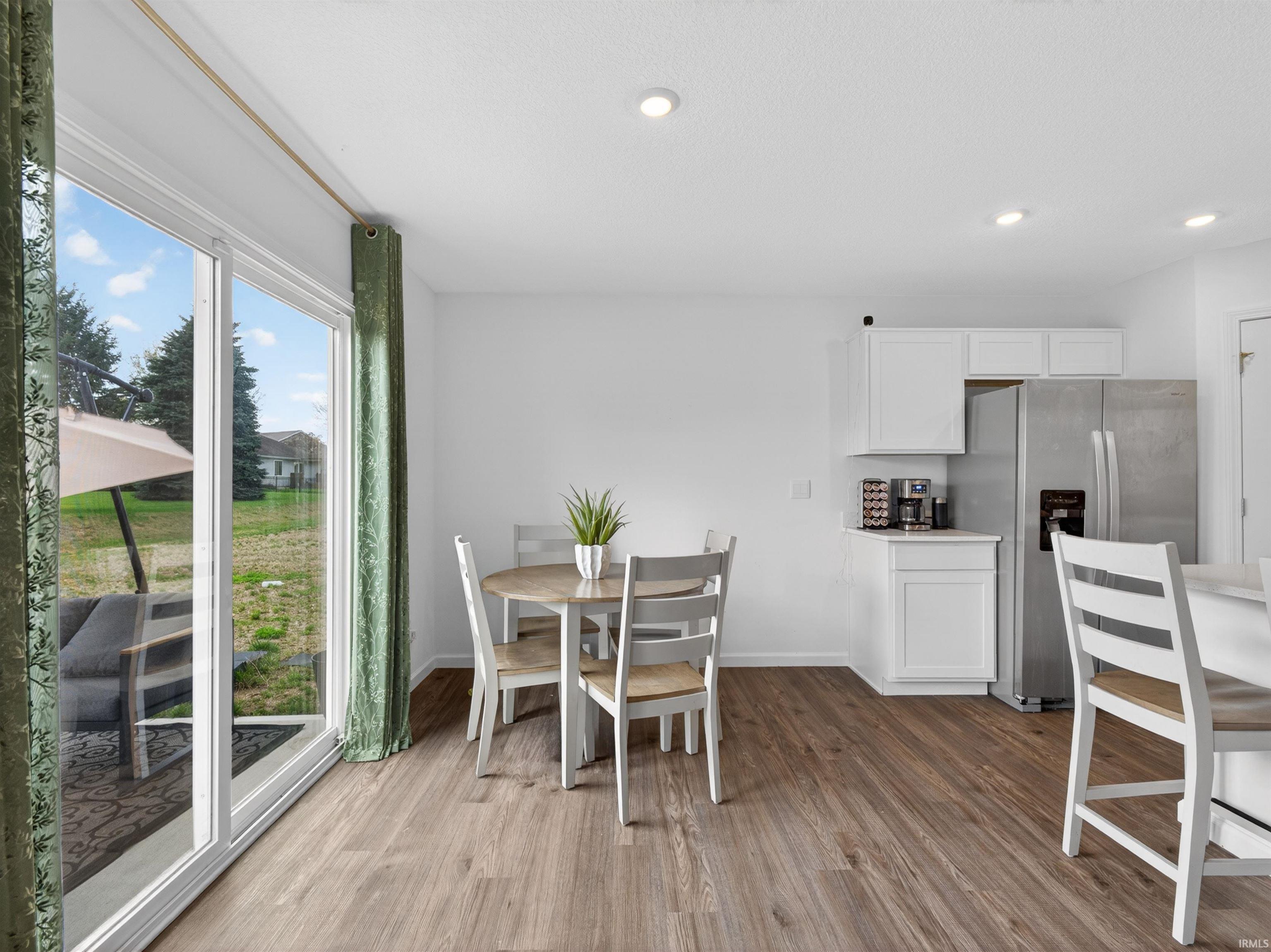 Dining area with light wood-type flooring and recessed lighting