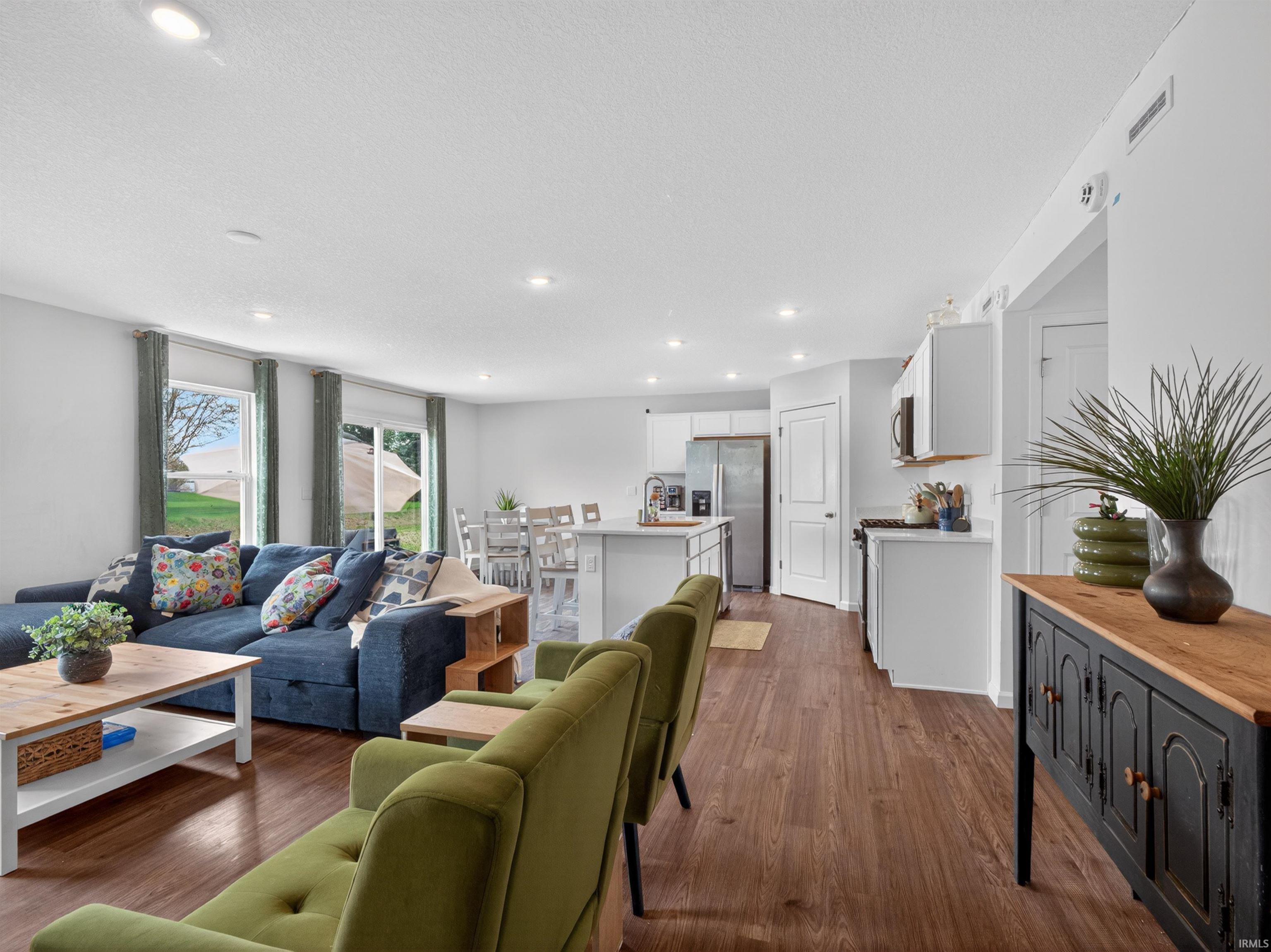 Living room with dark wood-type flooring and recessed lighting