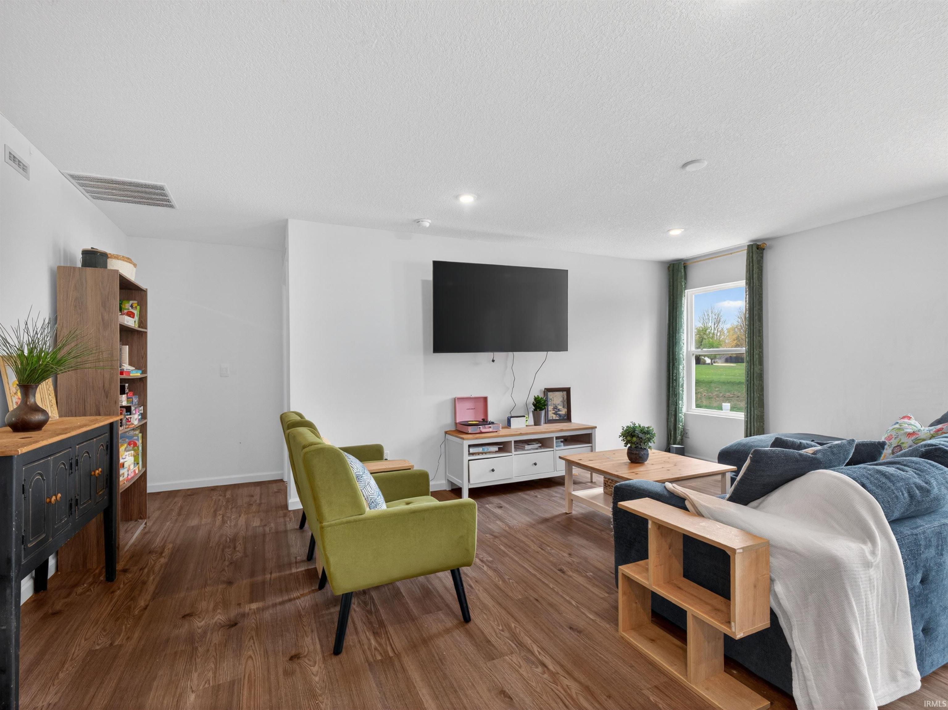 Living room featuring dark wood finished floors, recessed lighting, and a textured ceiling