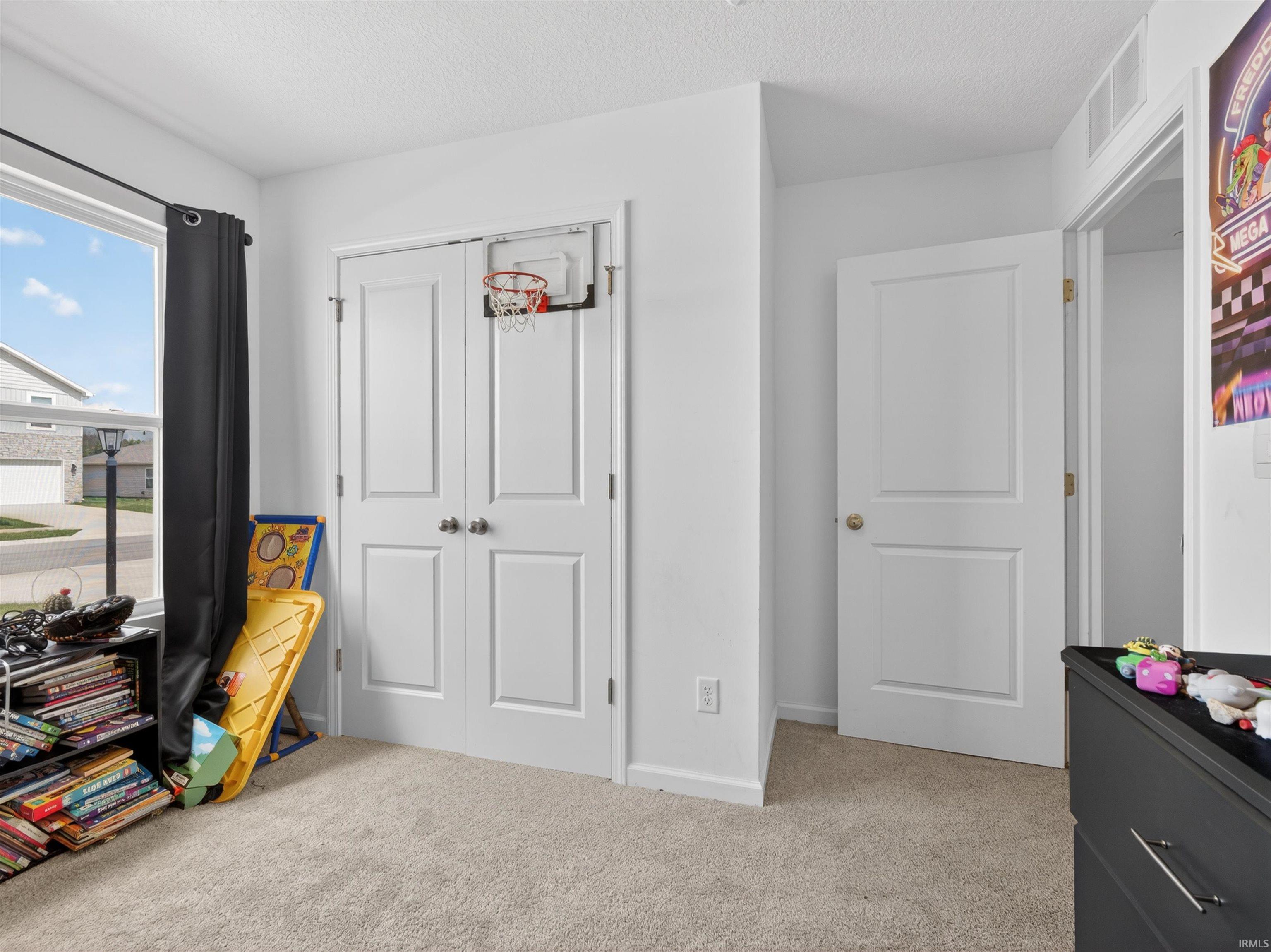 Playroom with light carpet and a textured ceiling