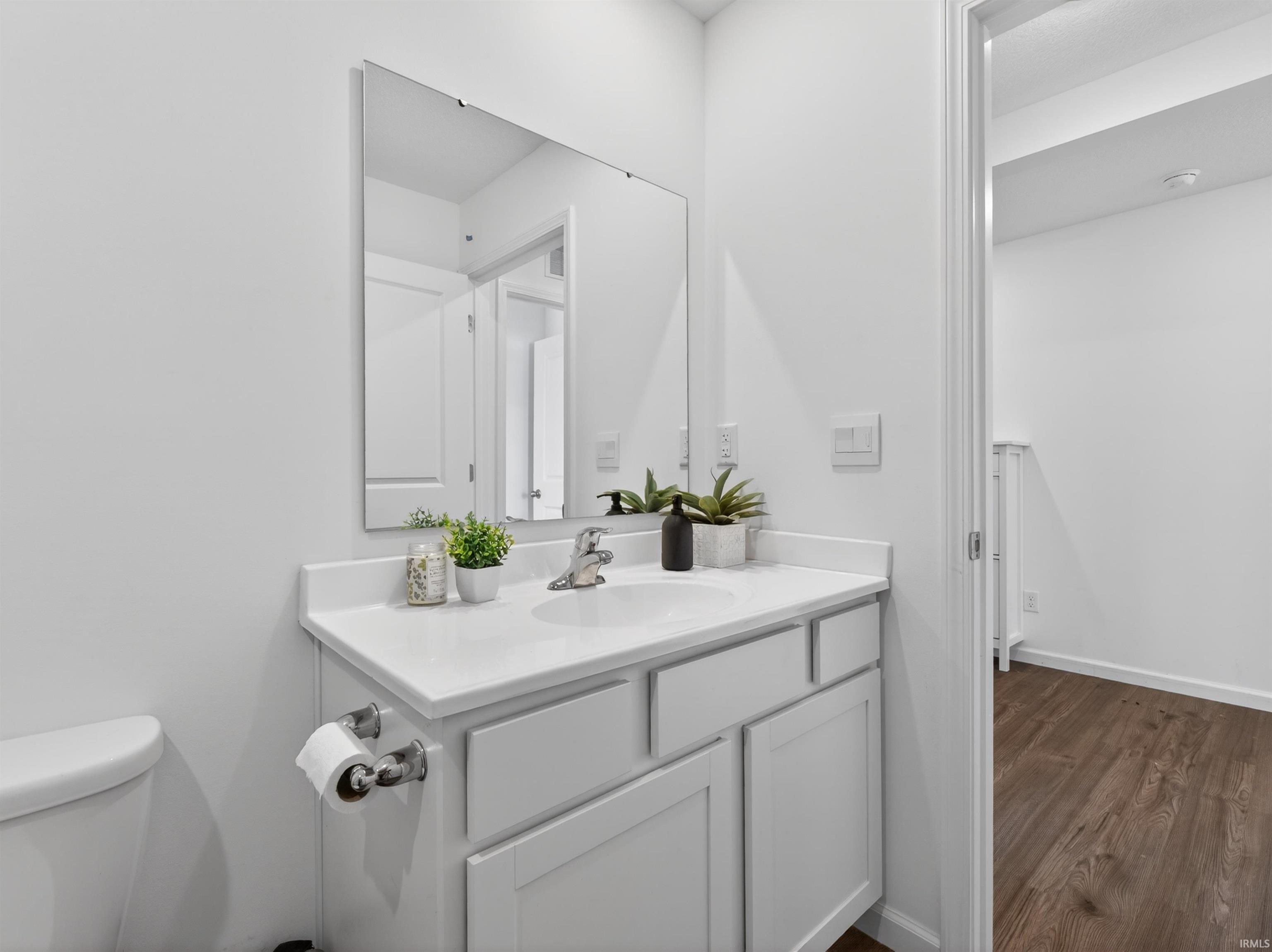 Half bath featuring vanity and dark wood-style flooring