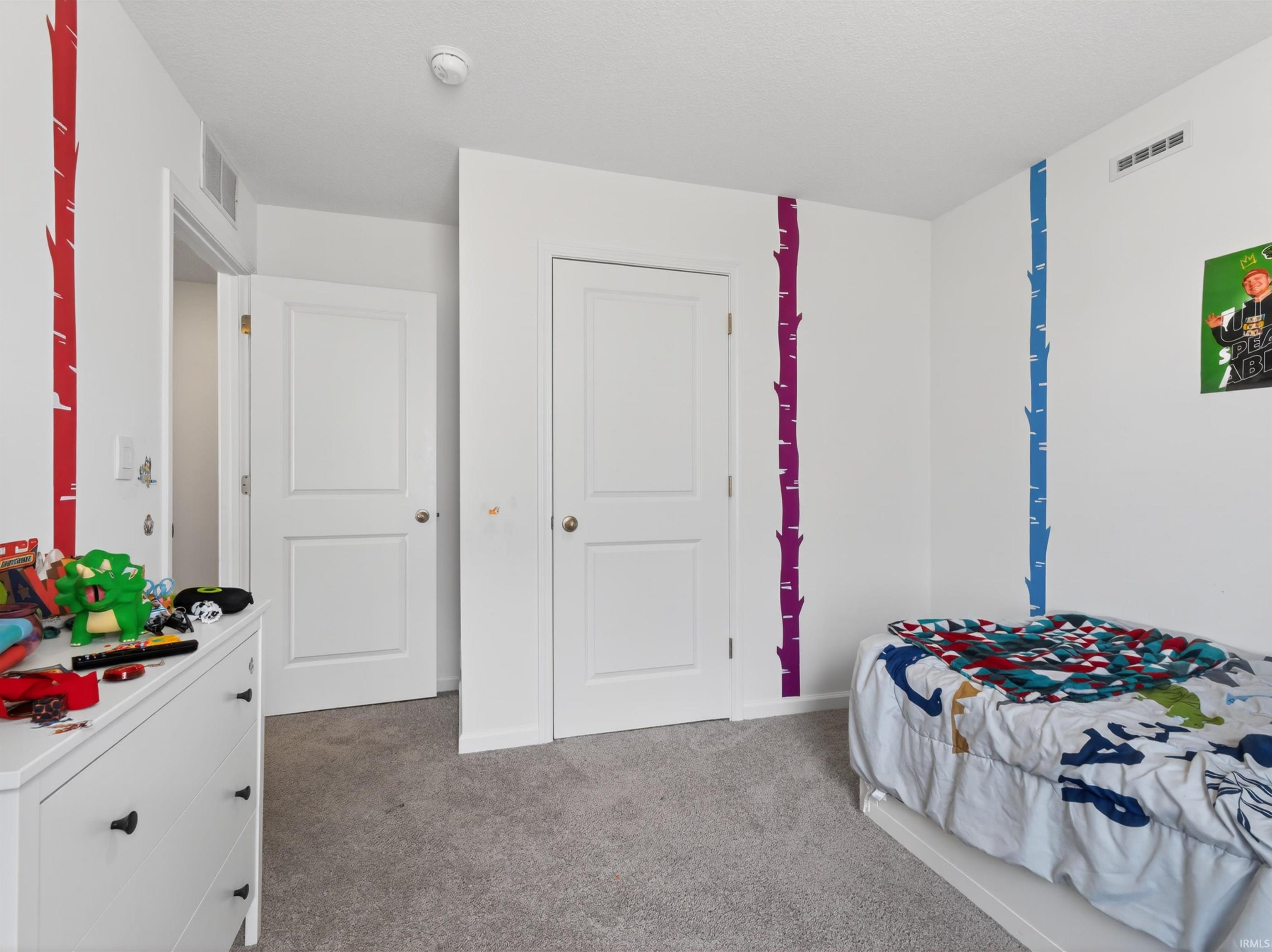 Bedroom with light colored carpet and baseboards