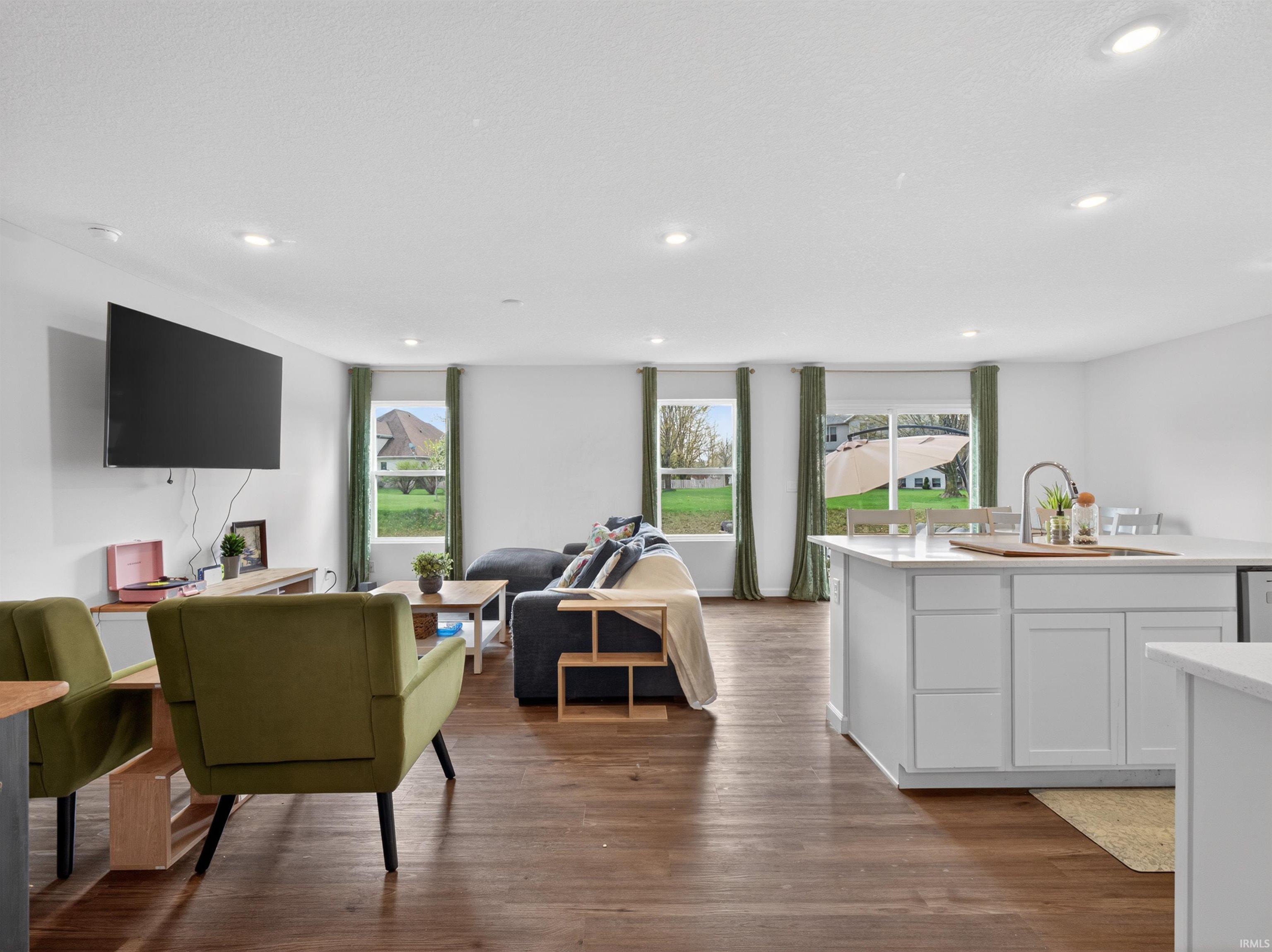 Living area with dark wood-style floors and recessed lighting