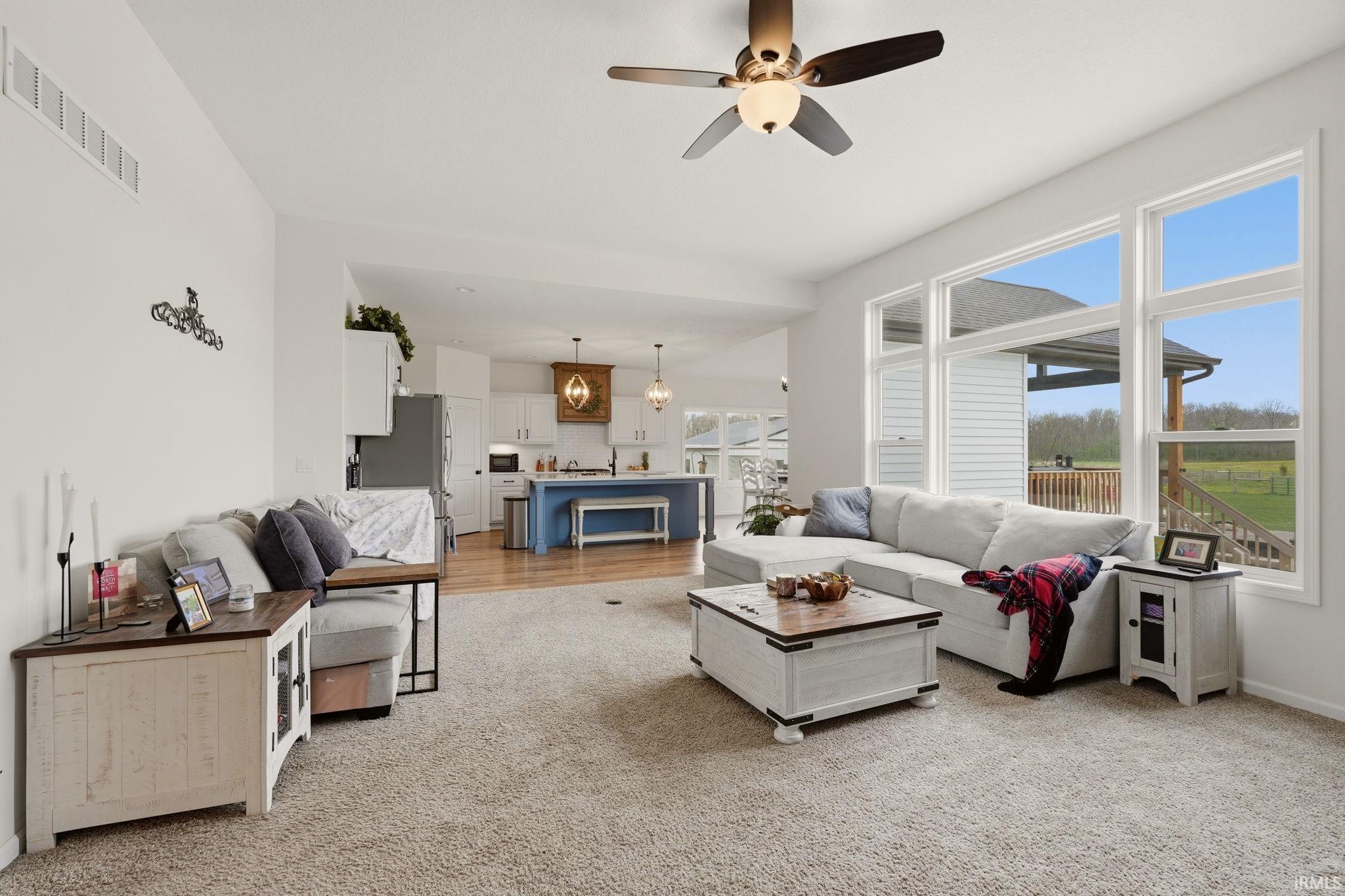 Living room featuring ceiling fan and light colored carpet