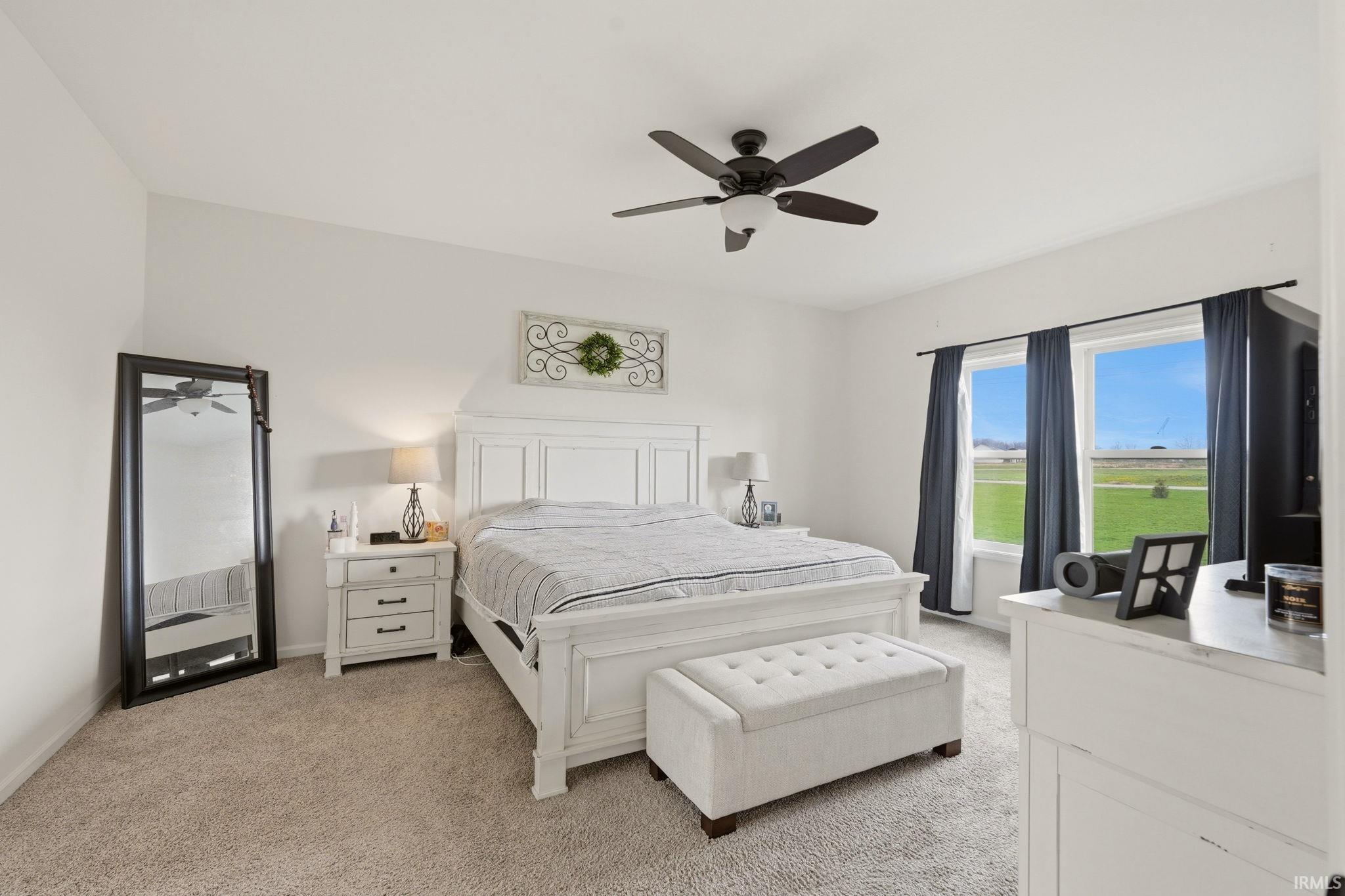Bedroom featuring light carpet and a ceiling fan