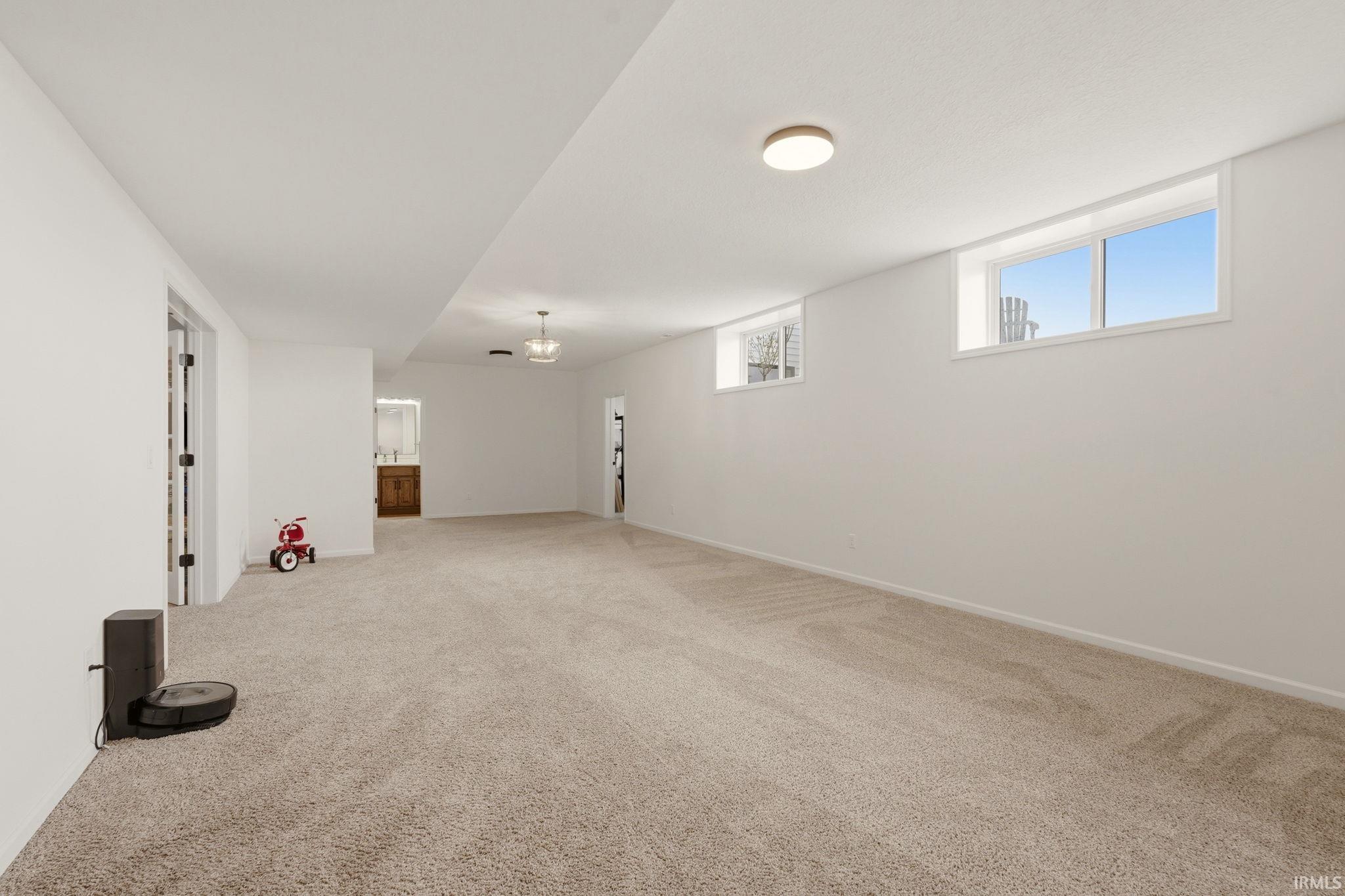 Below grade area featuring light colored carpet and baseboards
